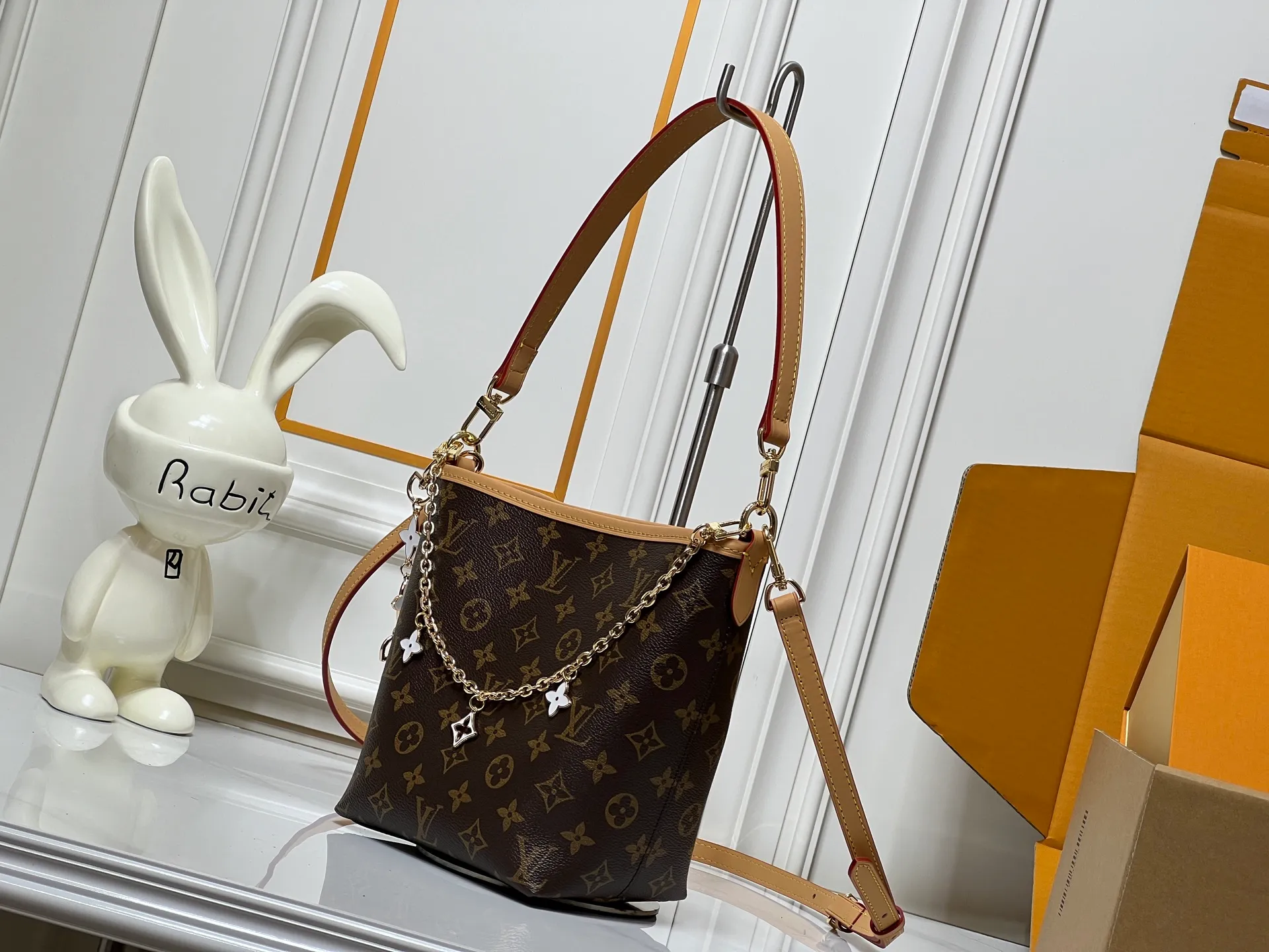 Batch 300💰M25666 All In BB Handbag It is made of the iconic Monogram presbyopic canvas, and the bag shape is simple yet stylish. Paired with a red leather shoulder strap, it can be worn on one shoulder or across the body, and can be carried flexibly. The body of the bag is also decorated with metal chain charms with brand elements and flower shapes, which adds a sense of sophistication and design to the whole. It not only retains the classic charm of LV, but also shows a unique fashion style through detailed design. It is a good choice to enhance the style and texture in daily matching. Size: 17x20x15cm