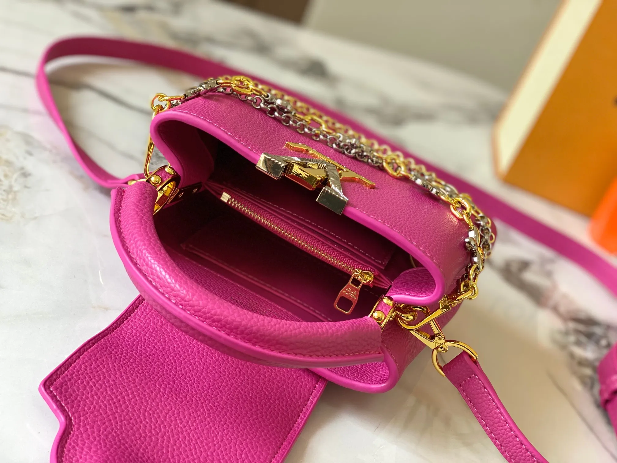 P480 [Guangzhou top quality original version] M26351 Rose Red This modern version of Capucines mini is made of timeless Taurillon leather and equipped with a jewelry-inspired Infinity chain. The bag is decorated with double galvanized metal parts, including the iconic Monogram floral pattern, and the LV Initials logo created with sunburst technology, creating a sundial-like light and shadow effect. The bag has multiple pockets and a detachable shoulder strap, allowing it to be carried on one shoulder or across the body. 14 x 8 x 21 cm (height x width x length)