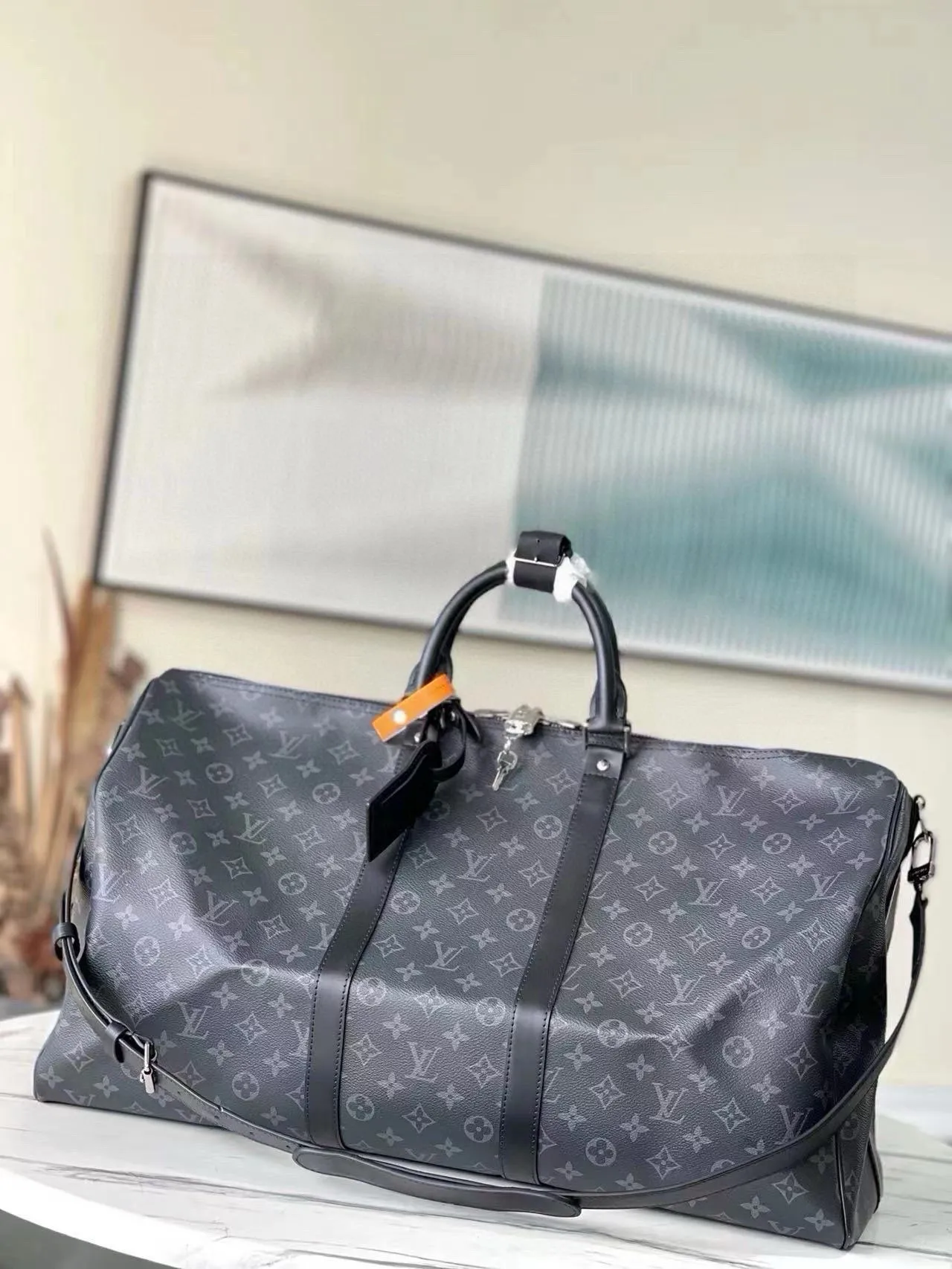 💰1040 (55 size) top original single M40605 black flower, spacious capacity, flexible use. Durable, safe and reliable. Fashionable style, mature and stable. Features a secure double zipper and padlock, making it perfect for business or pleasure. Size: 55x 31× 26cm