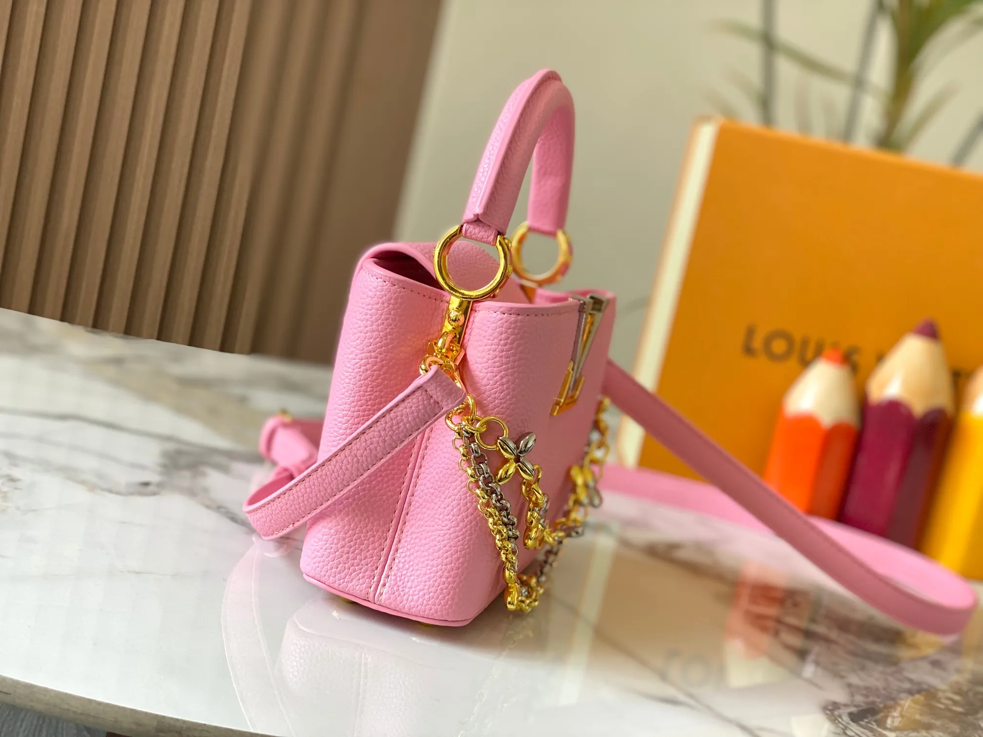P480 [Guangzhou top quality original version] M26351 Pink This modern version of Capucines mini is made of timeless Taurillon leather and equipped with a jewelry-inspired Infinity chain. The bag is decorated with double galvanized metal parts, including the iconic Monogram floral pattern, and the LV Initials logo created with sunburst technology, creating a sundial-like light and shadow effect. The bag has multiple pockets and a detachable shoulder strap, allowing it to be carried on one shoulder or across the body. 14 x 8 x 21 cm (height x width x length)