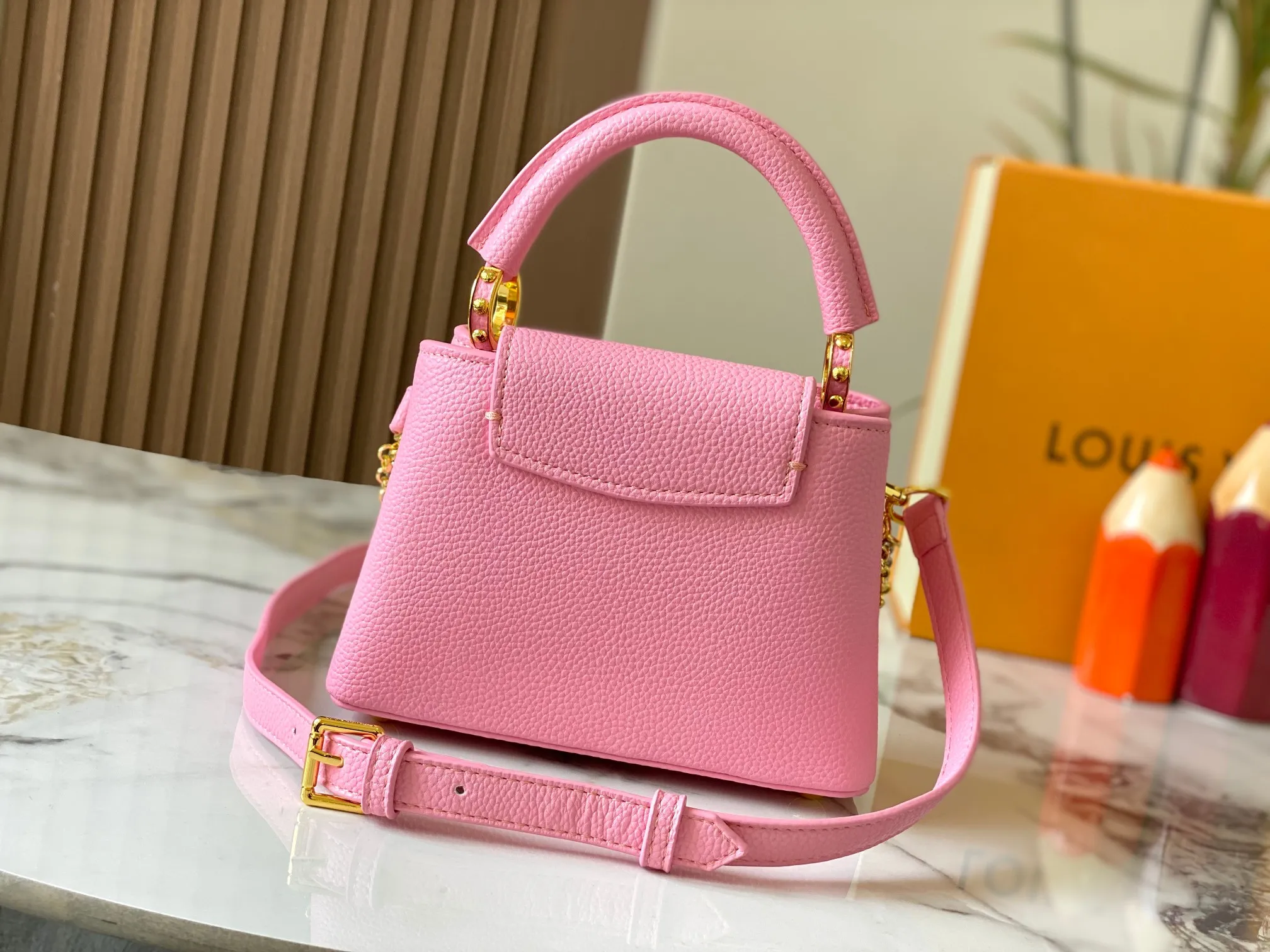P480 [Guangzhou top quality original version] M26351 Pink This modern version of Capucines mini is made of timeless Taurillon leather and equipped with a jewelry-inspired Infinity chain. The bag is decorated with double galvanized metal parts, including the iconic Monogram floral pattern, and the LV Initials logo created with sunburst technology, creating a sundial-like light and shadow effect. The bag has multiple pockets and a detachable shoulder strap, allowing it to be carried on one shoulder or across the body. 14 x 8 x 21 cm (height x width x length)