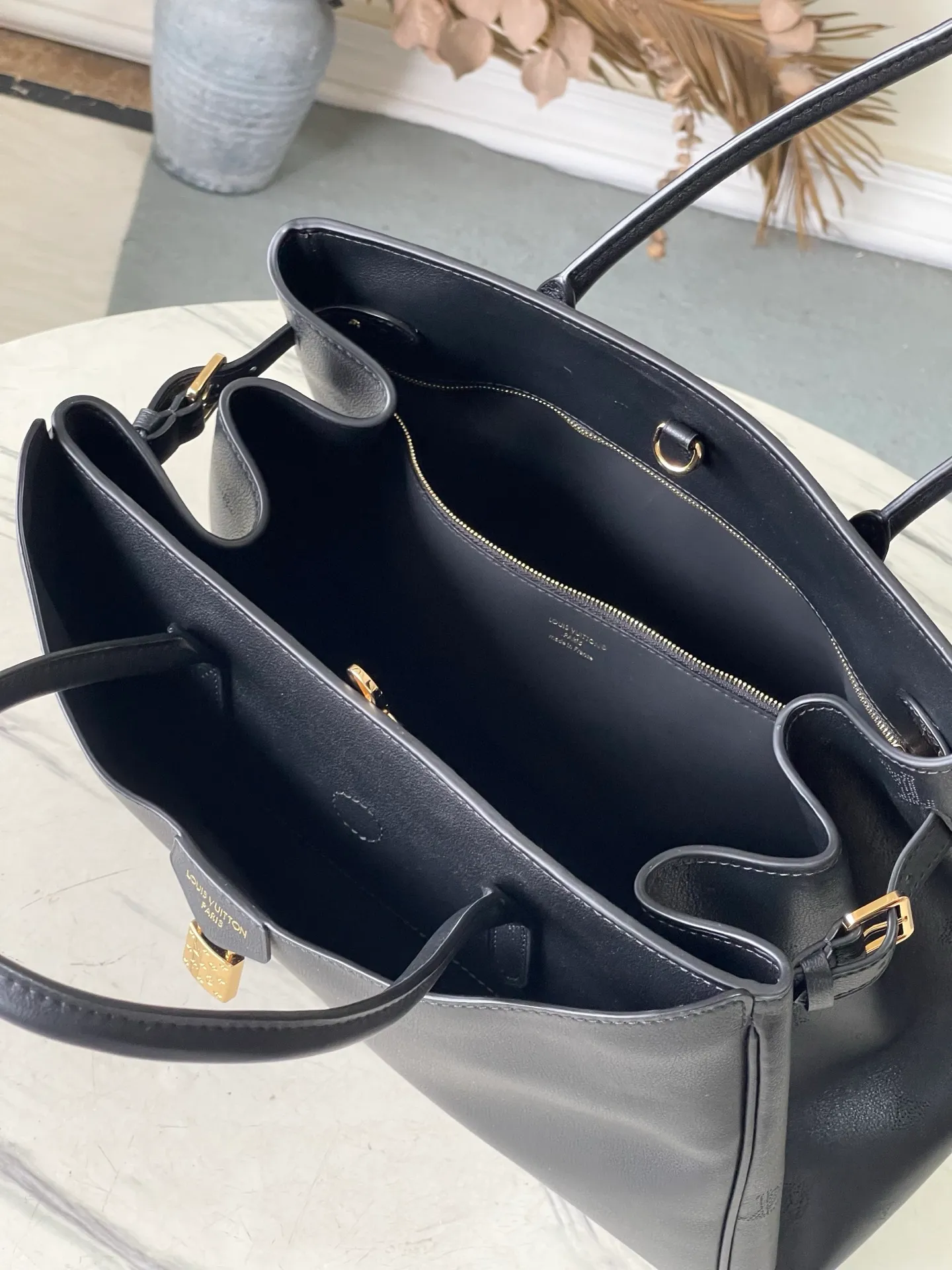 💰1480 (first-grain leather) top original order M26338 black large size This practical and stylish Vendôme handbag model perfectly displays freedom and modernity, and praises the brand's excellent craftsmanship. The handbag is made of black calfskin with a subtle satin effect finish, equipped with a gold buckle and a signature padlock engraved with the Monogram pattern in a low-key manner. This versatile tote features adjustable elasticated side straps and multiple pockets to securely store valuables. Dimensions: 35.5 x 28 x 17 cm (length x height x width)
