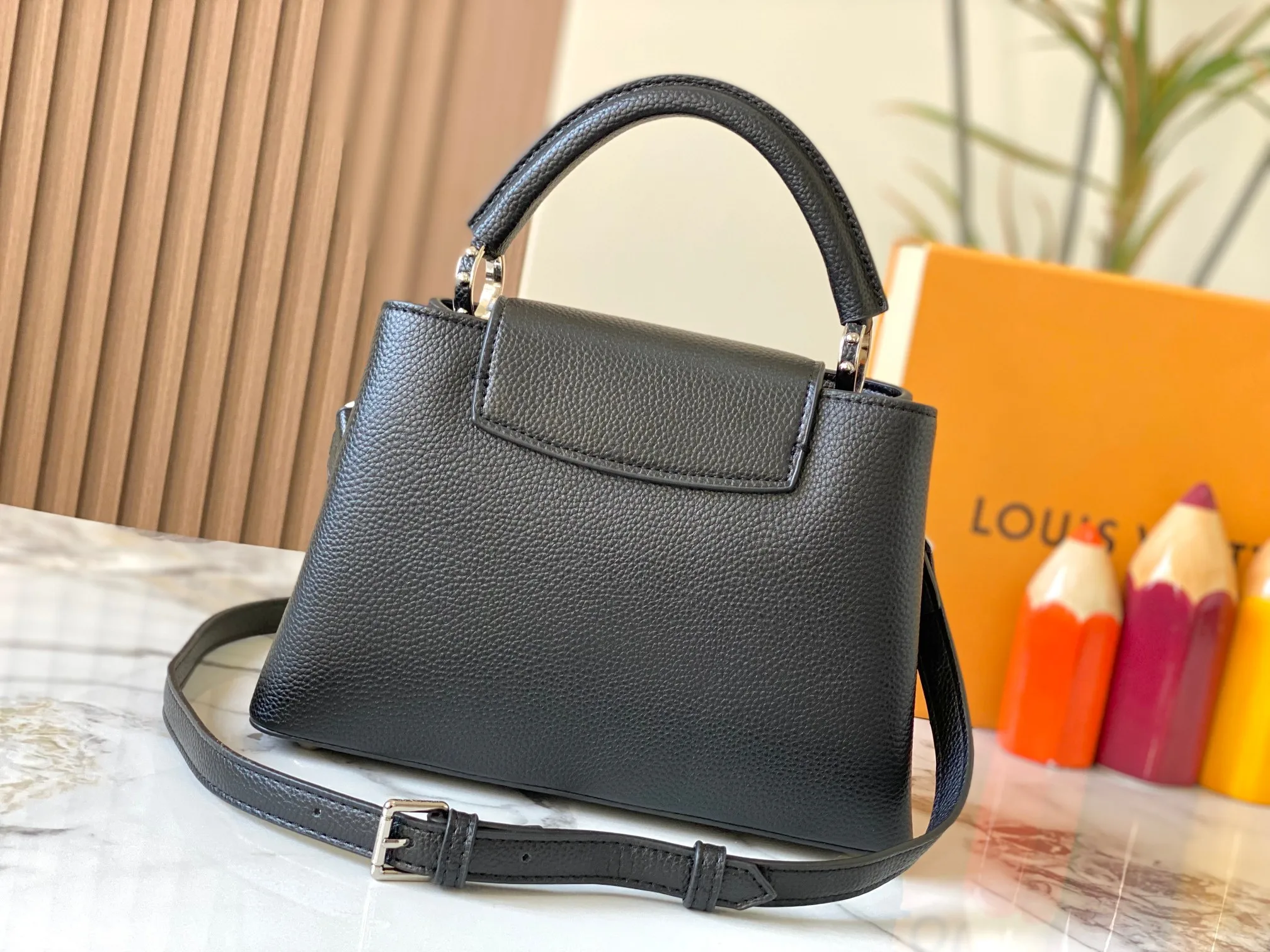 P500 [Guangzhou top quality original version] M26532 black silver This modern version of Capucines BB is made of timeless Taurillon leather and equipped with a jewelry-inspired Infinity chain. The bag is decorated with double galvanized metal parts, including the iconic Monogram floral pattern, and the LV Initials logo created with sunburst technology, creating a sundial-like light and shadow effect. The bag has multiple pockets and a detachable shoulder strap, allowing it to be carried on one shoulder or across the body. 27 x 17.3 x 9 (cm) (length x height x width)
