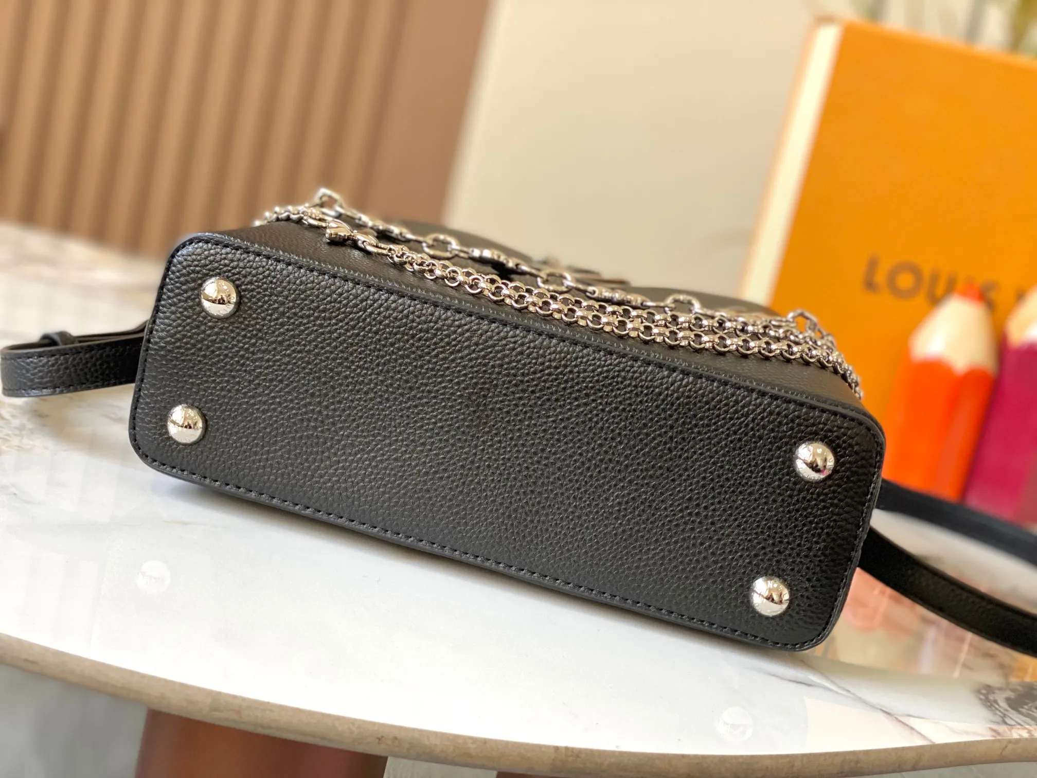 P500 [Guangzhou top quality original version] M26532 black silver This modern version of Capucines BB is made of timeless Taurillon leather and equipped with a jewelry-inspired Infinity chain. The bag is decorated with double galvanized metal parts, including the iconic Monogram floral pattern, and the LV Initials logo created with sunburst technology, creating a sundial-like light and shadow effect. The bag has multiple pockets and a detachable shoulder strap, allowing it to be carried on one shoulder or across the body. 27 x 17.3 x 9 (cm) (length x height x width)