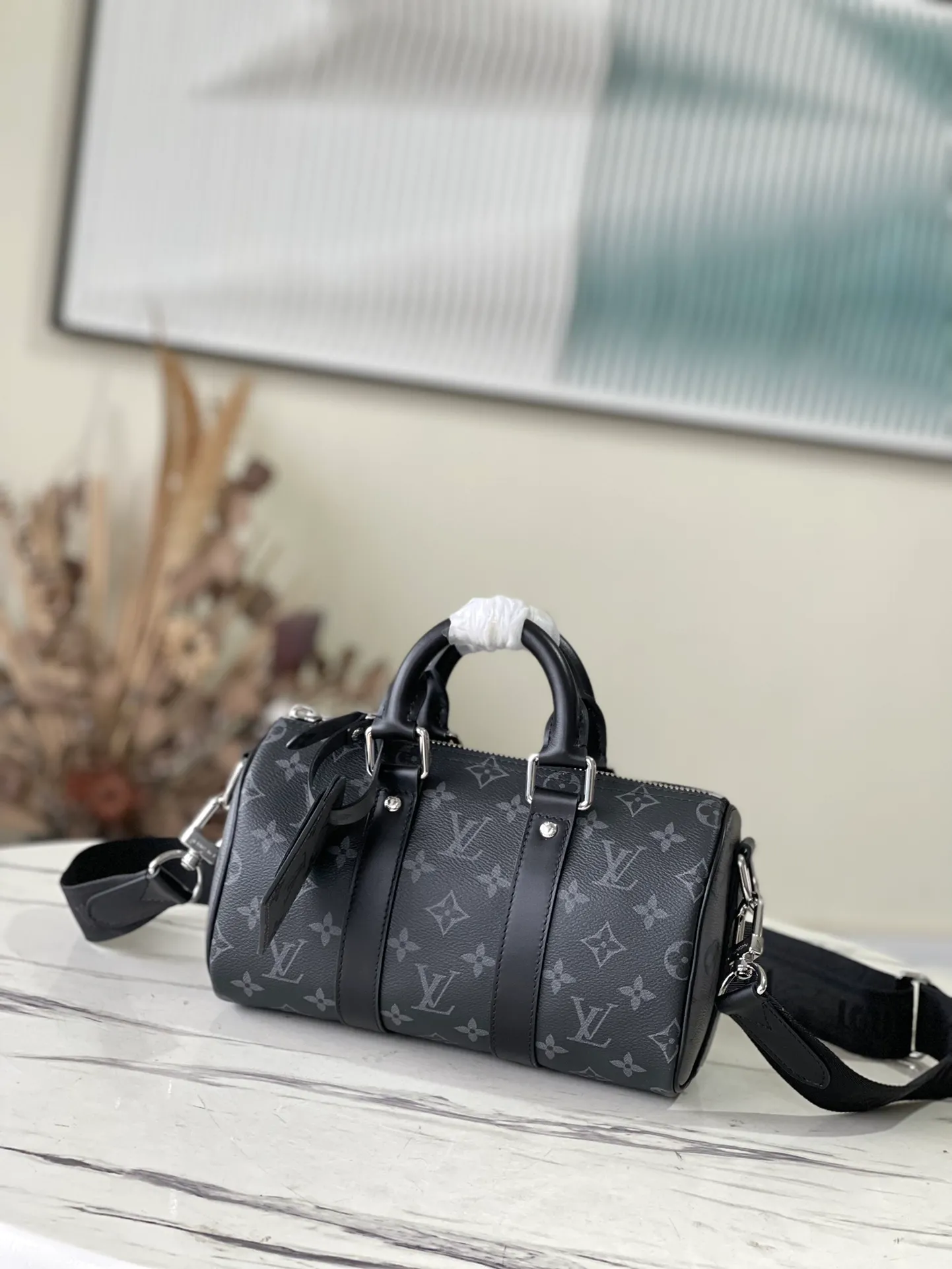 💰820 Top Original M46271 Black Flower This Keepall 25 handbag is made of Monogram Eclipse Reverse canvas, showing an elegant reinterpretation of the classic pattern. Reinforced straps and leather name tags are signature elements of the Keepall collection, while a zipper closure keeps personal items safe and secure. Dimensions: 25 x 15 x 11 cm
