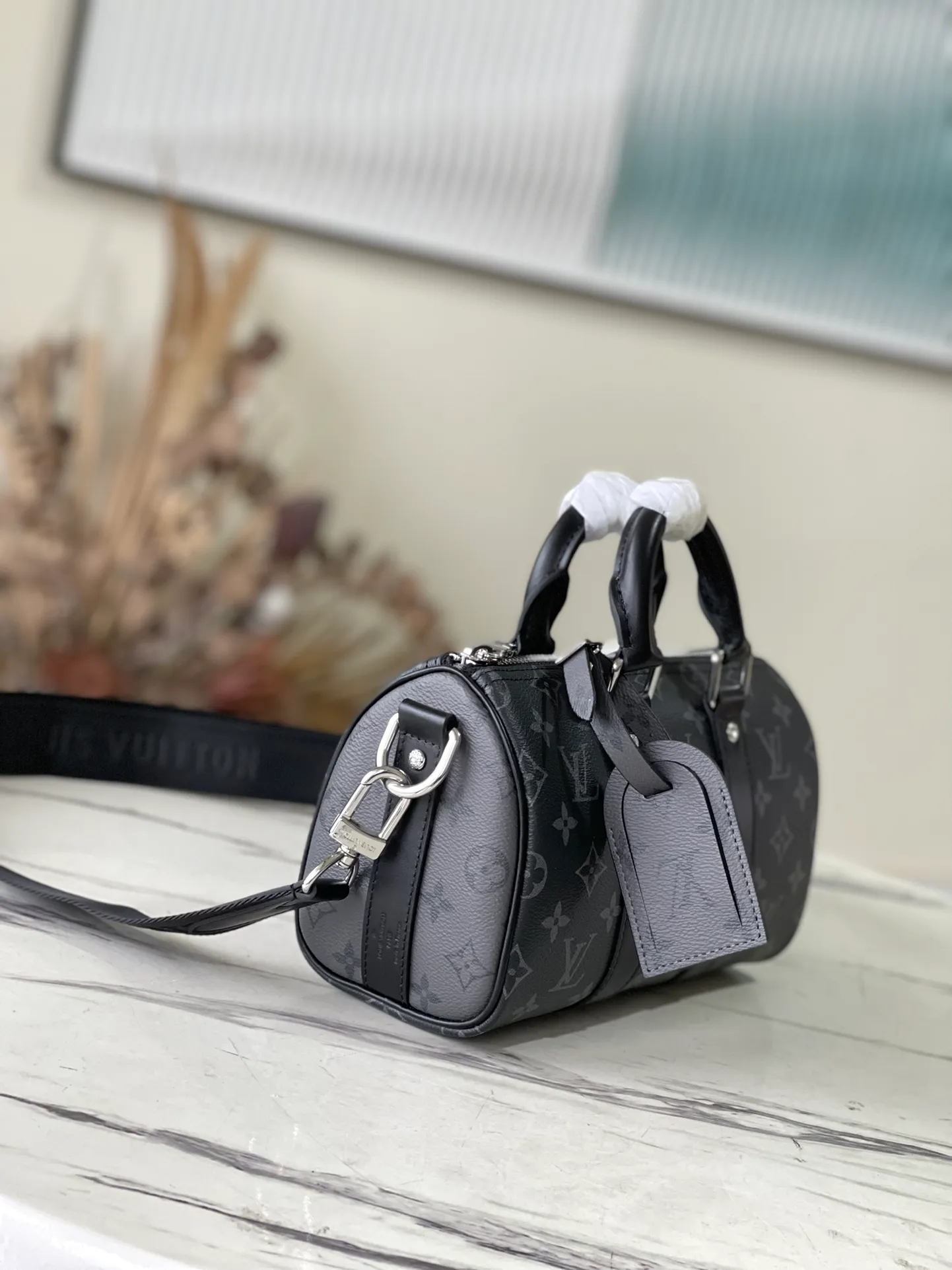 💰820 Top Original M46271 Black Flower This Keepall 25 handbag is made of Monogram Eclipse Reverse canvas, showing an elegant reinterpretation of the classic pattern. Reinforced straps and leather name tags are signature elements of the Keepall collection, while a zipper closure keeps personal items safe and secure. Dimensions: 25 x 15 x 11 cm