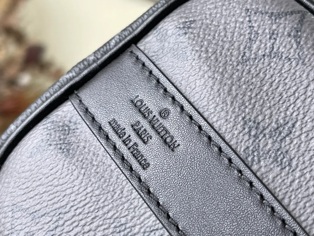 💰820 Top Original M46271 Black Flower This Keepall 25 handbag is made of Monogram Eclipse Reverse canvas, showing an elegant reinterpretation of the classic pattern. Reinforced straps and leather name tags are signature elements of the Keepall collection, while a zipper closure keeps personal items safe and secure. Dimensions: 25 x 15 x 11 cm
