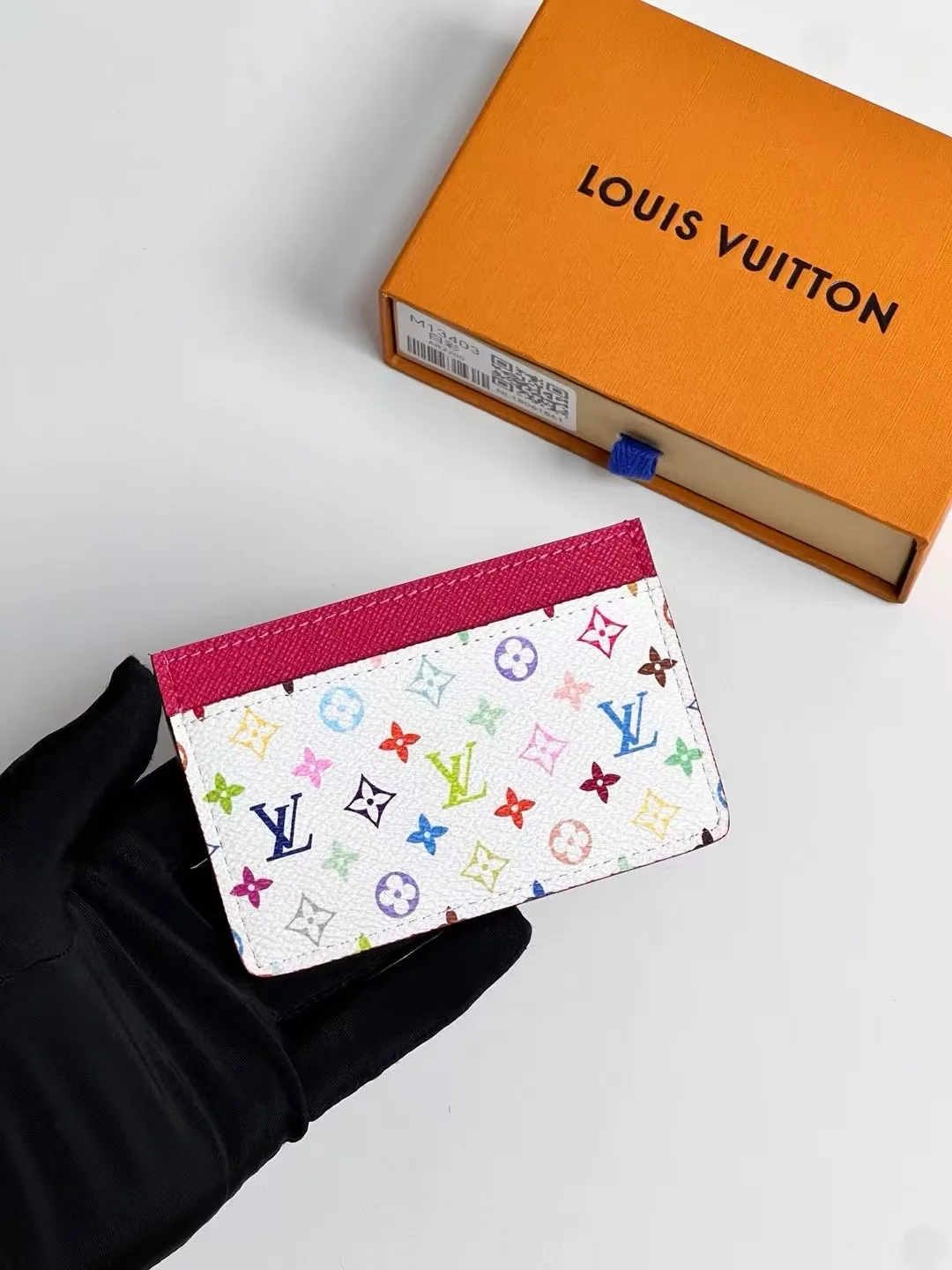 p100 M13403 Black color! LV x TM business card holder, this re-engraved version of the classic business card holder from the Louis Vuitton x Murakami collaboration series is reinterpreted in playful rainbow tones. Made of coated canvas, the classic Monogram pattern is designed in the extremely bright and iconic colors of Japanese artist Takashi Murakami, and the top is decorated with a bright pink color. The interior of the business card holder is suitable for large business cards and receipts, while the exterior features two classic business card compartments.  11 x 7 x 0.5 cm (length x height x width).