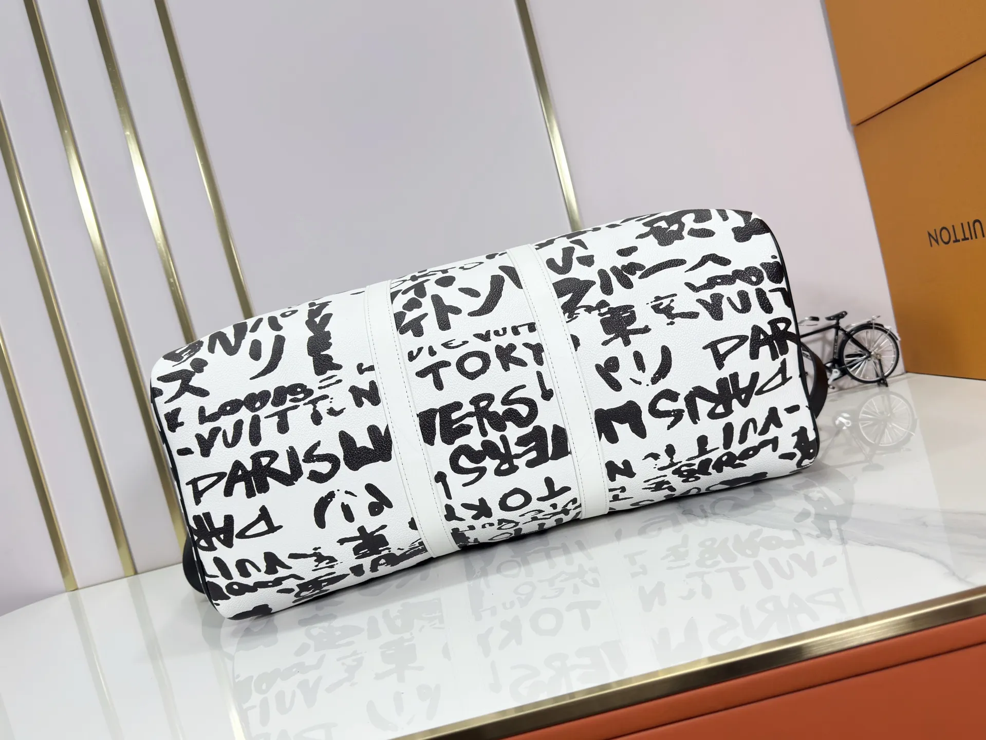 P340 M40805 M40804 M41416 The upgraded original Keepall Bandoulière 50 travel bag was jointly created by Japanese designers Nigo and Pharrell Williams. It is laid out with elegant plaid on the cow leather, and then has eye-catching words written in French and Japanese. A cotton lining pattern bears witness to Nigo's artistic vision, and a removable LV Dynasty nameplate highlights the brand's identity.  29 cm