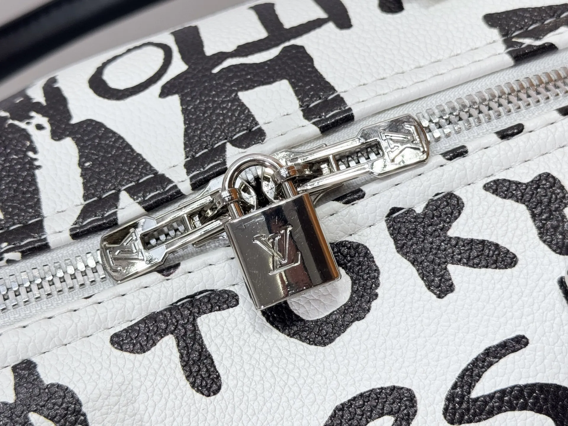 P340 M40805 M40804 M41416 The upgraded original Keepall Bandoulière 50 travel bag was jointly created by Japanese designers Nigo and Pharrell Williams. It is laid out with elegant plaid on the cow leather, and then has eye-catching words written in French and Japanese. A cotton lining pattern bears witness to Nigo's artistic vision, and a removable LV Dynasty nameplate highlights the brand's identity.  29 cm