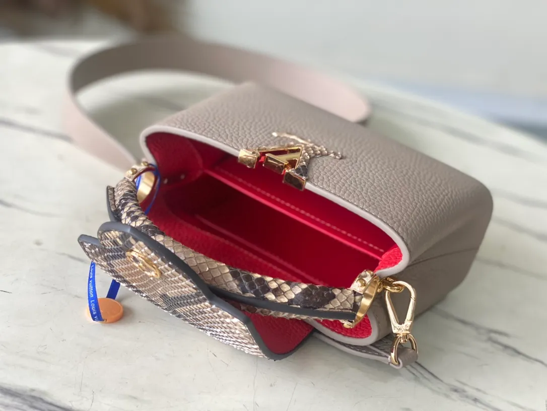 💰2260 (Special Grade Original Leather) N80931 Elephant Gray Red Interior Mini This Capucines mini handbag is made of dark-dyed Taurillon leather, with gorgeous python leather embellishments on the handles and flap. Whether carried by hand or worn on the shoulder with the wide shoulder strap, you can create an eye-catching style in any occasion. Dimensions: 21 x 14 x 8 cm