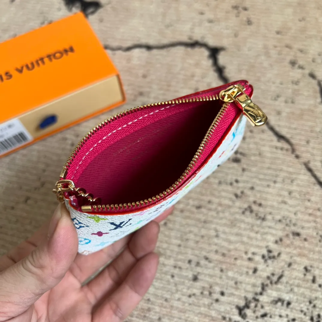 Factory price 280 Top-quality original order M13664 white color This replica Louis Vuitton x Murakami series key coin purse is colorful and made of coated canvas. The vibrant iconic Monogram pattern reinterprets the brand logo with the theme of Japanese artist Takashi Murakami in rainbow tones. The key coin purse has a silver zipper and is equipped with a chain strap and hook buckle to store keys securely. 12 x 7 x 1.5 cm (length x height x width)