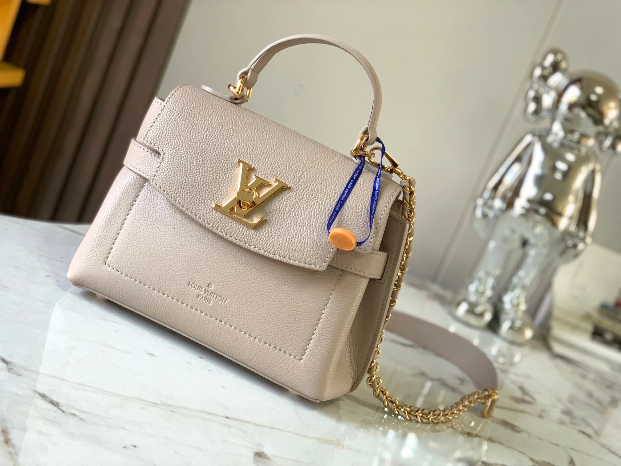 P1440【Original Leather💋M21052 Elephant Gray】This season, the small and exquisite Lockme Ever handbag is dyed in a fashionable new color of grained cow leather. Exquisite lines and the iconic LV padlock convey a trendy style. The elegant woven chain strap allows you to choose between cross-body or shoulder carry, and the top handle makes holding it more gentle. It is a perfect choice for carrying around day and night.   Detailed features 23 x 17x10 cm (length x height x width)