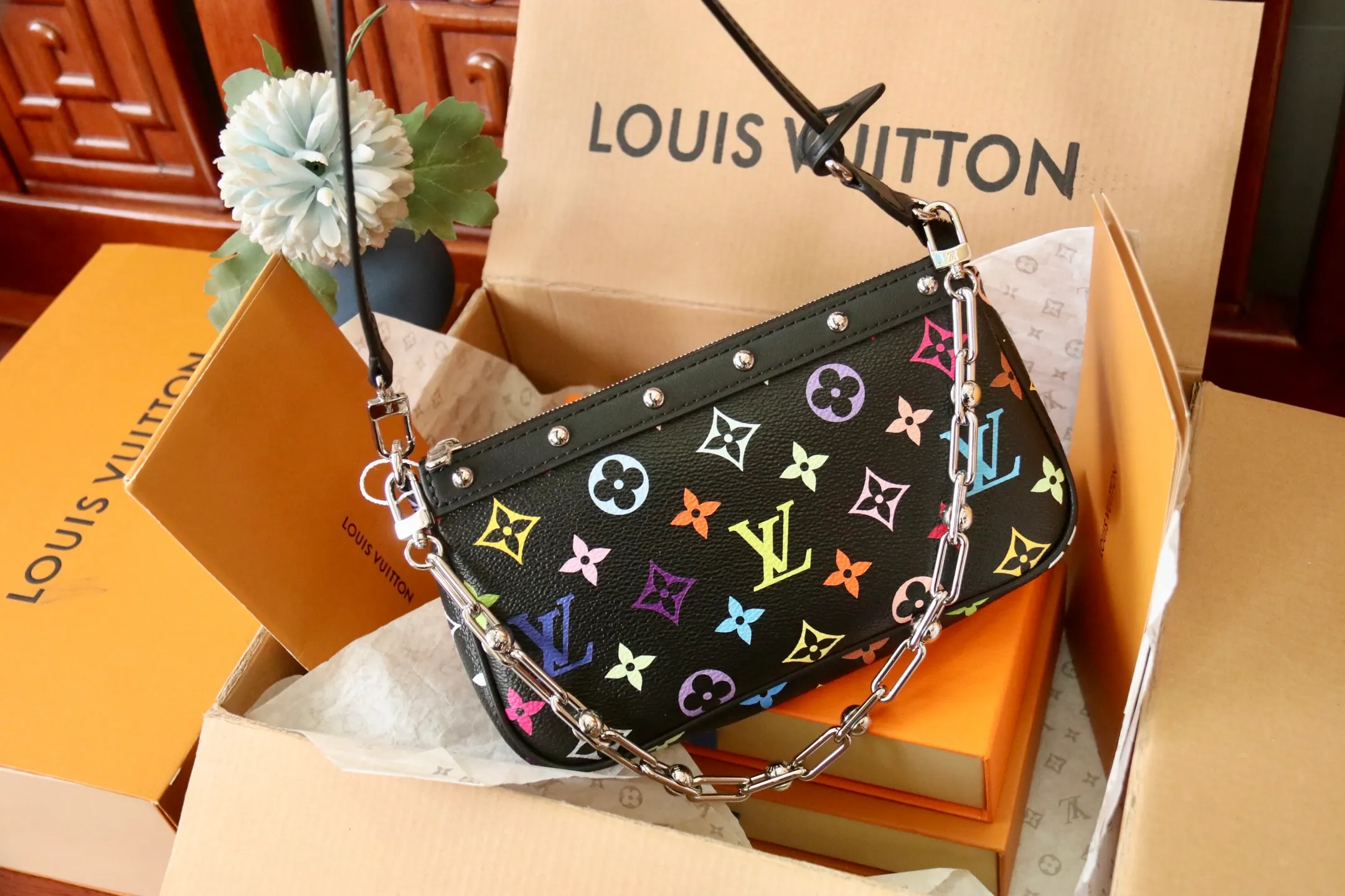 The top original P720 M13404 black Pochette Accessoires handbag is made of coated canvas and uses colorful Monogram patterns to interpret the smart style of the Louis Vuitton x Murakami cross-border collaboration series. Calf leather trim and dazzling hardware add to the sophisticated details, while the detachable shoulder strap and chain allow for flexible carry. 13 x 4 x 22 cm (height x width x length)