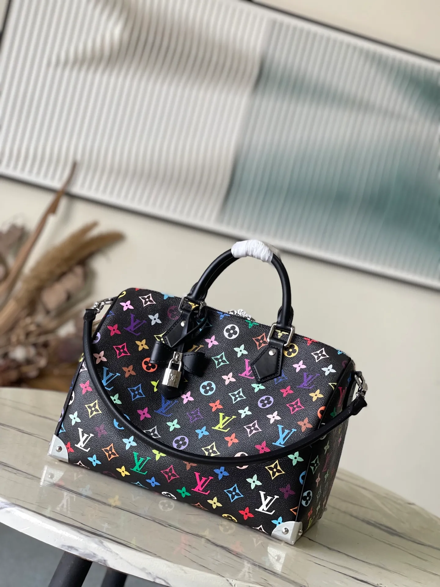 💰1180 (top layer leather) top original order M13257 This SpeedySoft 30 handbag is made of soft coated canvas, and the full-length Monogram pattern is traced in colorful rainbow tones, highlighting the smart style of the x Murakami Takashi reissue series. The Toron handle and detachable shoulder strap are constructed of cow leather, the metal corners recall classic luggage elements, and the bow-shaped key bag and padlock add brand touches. Dimensions: 30 × 21 × 17 cm
