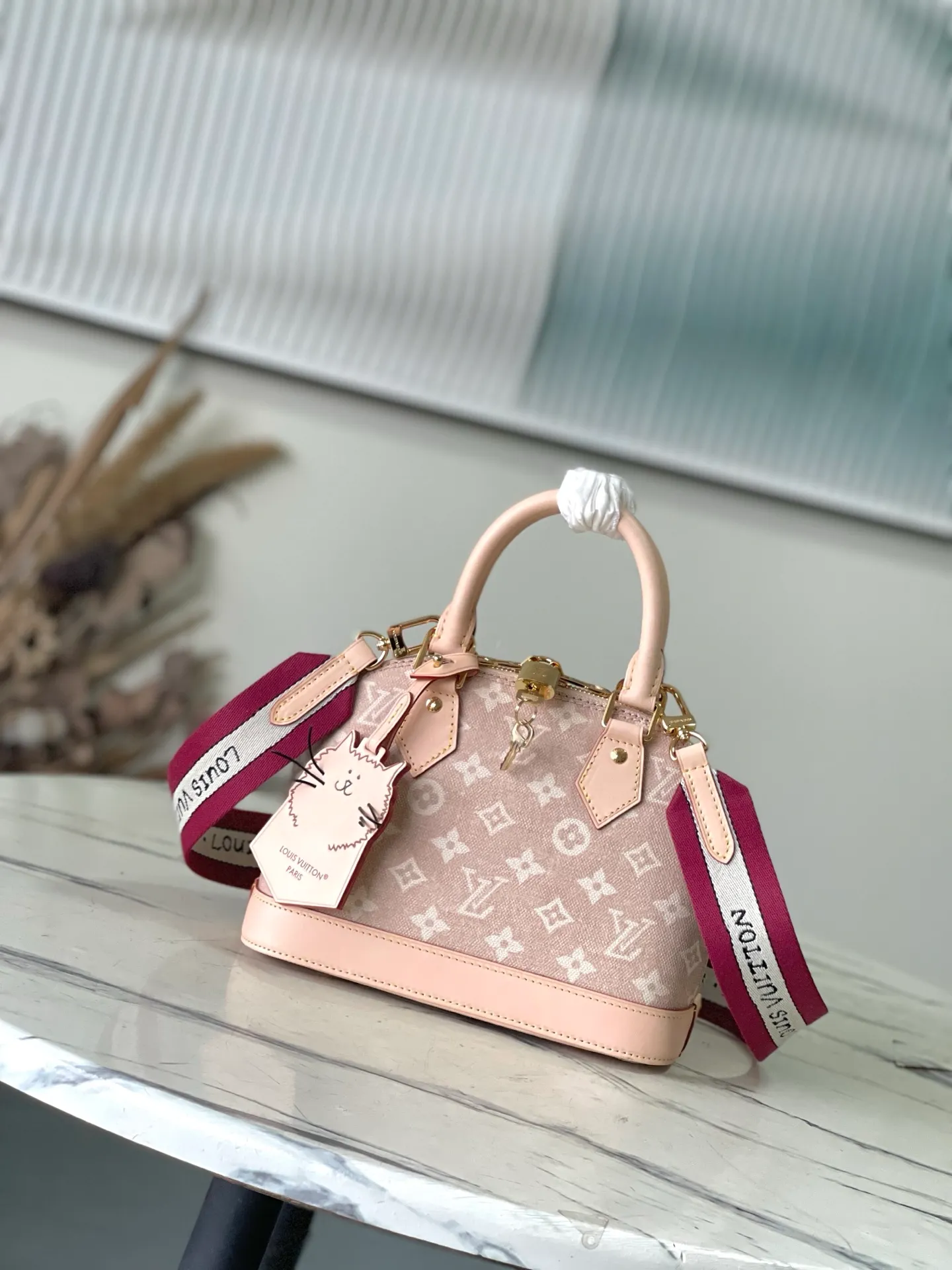 💰1180 Top Original Order M25728 This AlmaBB handbag comes from the Travels With Grace Coddington series launched by Louis Vuitton and Grace Coddington, focusing on the fun Meowgram pattern. The canvas bag is trimmed with cow leather, and the fabric shoulder strap displays the word "Louis Vuitton" in Coddington's handwriting. The exquisite padlocks and key cases once again prove the brand's exquisite craftsmanship. Dimensions: 23.5 × 17.5 × 11.5 cm