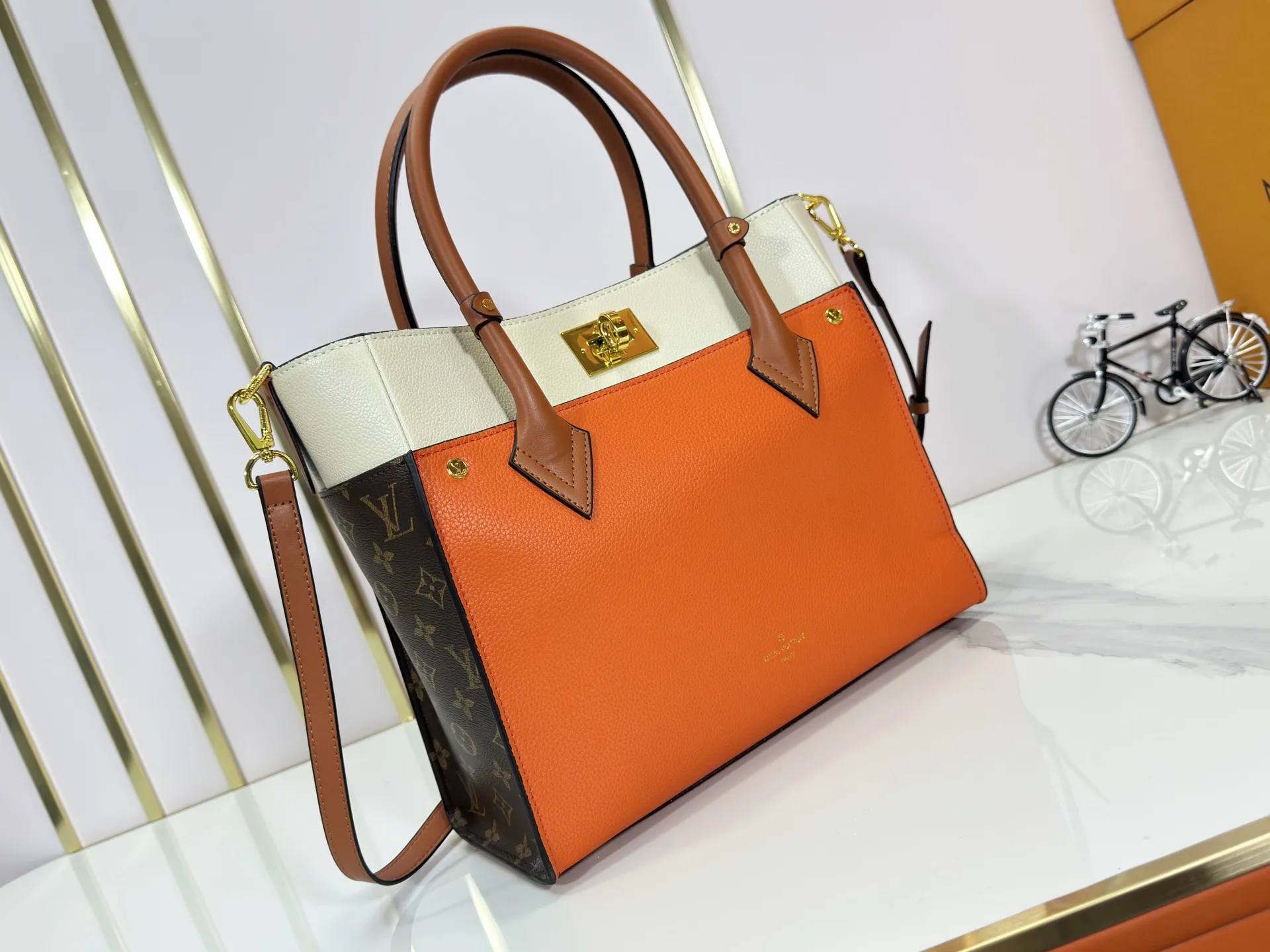 P340 upgraded original M53826 M53825 M53824 M53823On My Side handbag shows the elegant fusion of calfskin and classic Monogram canvas. Contrasting canvas shapes the large outer pocket, creating a trompe l'oeil effect as if two handbags merge into one. Plenty of space can easily accommodate office needs, and the adjustable shoulder strap allows for a cross-body style. Dimensions: 30.5 x 24.5 x 14 cm (Length x Height x Width) - Calfskin and Monogram coated canvas - Cowhide leather trim - Microfiber lining - 2 top handles for hand or elbow carry - Adjustable shoulder strap for shoulder or cross-body wear - Lock closure - 2 outer pockets with magnetic closure - Zip pocket - 1 patch pocket