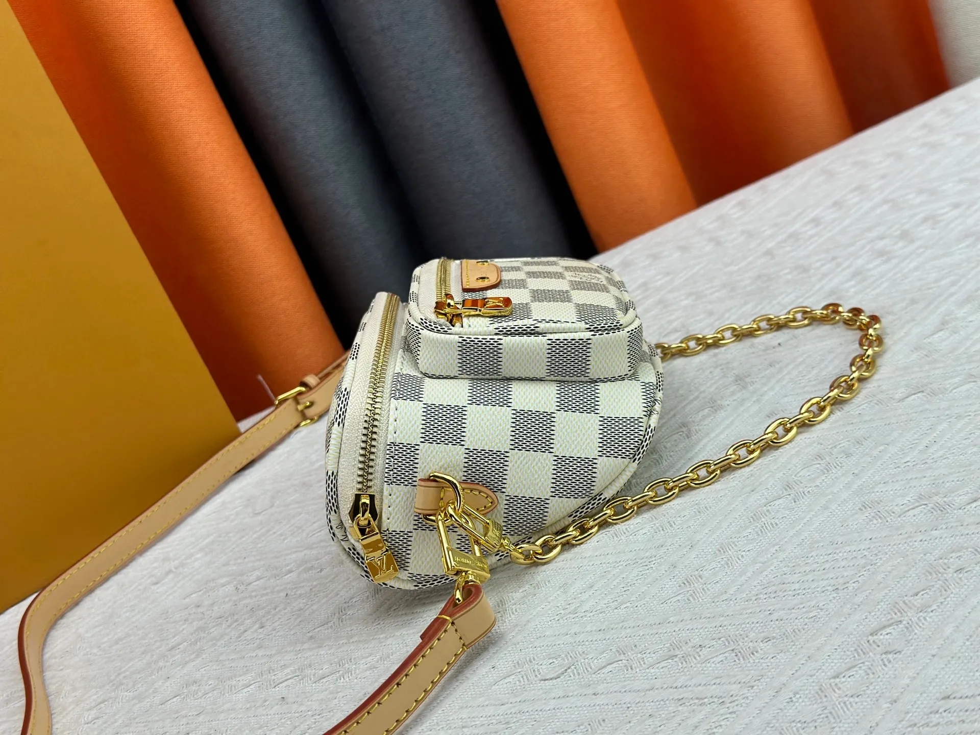 P240 M82208 M00130 M82335 This Mini Bumbag handbag comes from the LV Gradient series. The Monogram embossing of Monogram Empreinte leather renders the gradient midsummer color. The on-trend construction features a zipped main compartment and a front pocket with a Louis Vuitton leather label. With the detachable chain and detachable and adjustable shoulder strap, it can be worn as a shoulder or cross-body bag. Dimensions: 17x12x9.5 cm