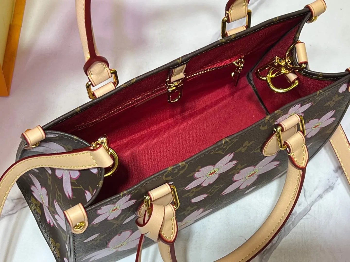 Batch 260💰M45659 M13668!🔥Lv&Takashi Murakami🐼Sakura🌸OnTheGo small new version The legendary ONTHEGO handbag: always able to meet your various needs for handbags. It has a large capacity but is not bulky. It is stiff and soft to the touch, making it suitable for home and travel. Tighten the side ties and it instantly transforms into a stylish urban handbag. Loosen the straps and it transforms into a chic and practical handbag. The slender leather handle can be carried over the shoulder or between the arms. The model shown here is made of Damier Azur canvas. Size: 25x11x19cm