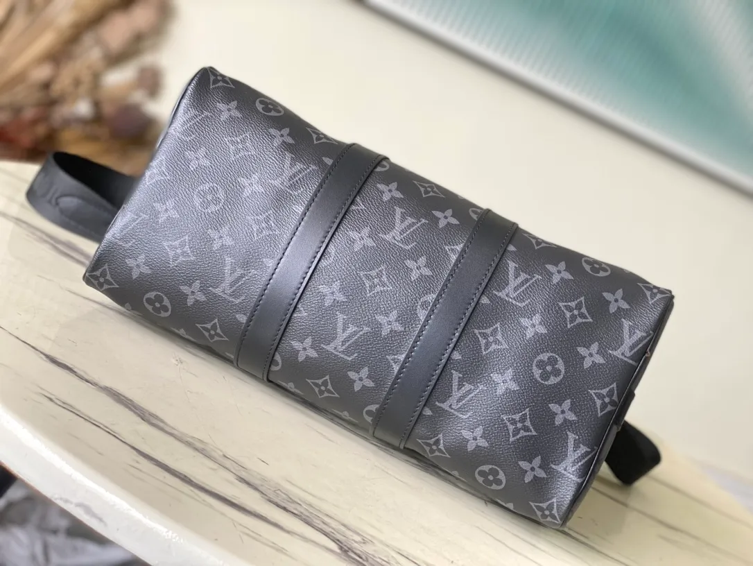 💰960 Top Original M46655 Black Flower Keepall Bandoulière 35 Handbag is a miniature version of the classic Keepall holiday travel bag. Full-grain Taurillon leather embossed with the Monogram pattern, leather side straps and top leather handle continue the signature elements of the Keepall collection, and the shoulder strap is removable and adjustable. Dimensions: 34 x 21 x 16 cm