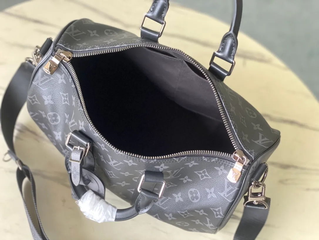 💰960 Top Original M46655 Black Flower Keepall Bandoulière 35 Handbag is a miniature version of the classic Keepall holiday travel bag. Full-grain Taurillon leather embossed with the Monogram pattern, leather side straps and top leather handle continue the signature elements of the Keepall collection, and the shoulder strap is removable and adjustable. Dimensions: 34 x 21 x 16 cm