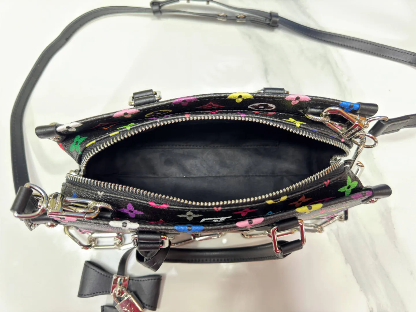 P300 Upgraded Original M13260 M46653 Takashi Murakami Collaboration Black Color White Color This OnTheGo East West handbag is made of cow leather to create a slender shape, and the Monogram flower nameplate completes the elegant style. Articulated handles and a detachable leather chain strap allow for a variety of carrying options. Size: 25x13x10cm
