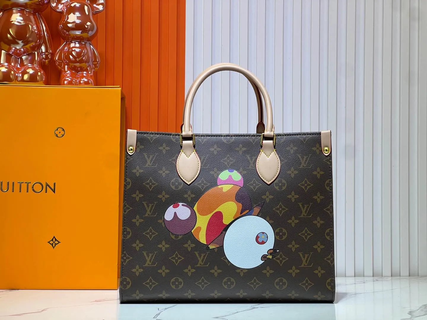 Batch 300💰M45039 M13668!🔥Lv&Takashi Murakami🐼Panda print OnTheGo new version The legendary ONTHEGO handbag: always able to meet your various needs for handbags. It has a large capacity but is not bulky. It is stiff and soft to the touch, making it suitable for home and travel. Tighten the side ties and it instantly transforms into a stylish urban handbag. Loosen the straps and it transforms into a chic and practical handbag. The slender leather handle can be carried over the shoulder or between the arms. The model shown here is made of Damier Azur canvas. Size: 35x27x14cm