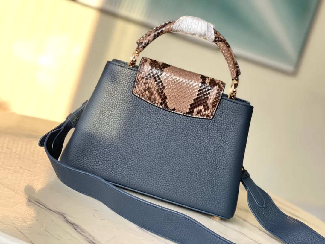 💰2460 (Special grade original leather) N99387/M48865 Dark Blue Snake Shoulder This Capucines BB handbag is made of full-grain Taurillon leather and has a sophisticated structure. It has a top handle, a two-way flap and a logo outlined in python snakeskin, making it a gorgeous choice for day and night. The detachable wide shoulder strap can be worn on the shoulder or cross-body for a bold and edgy look. Size: 27*18*9cm