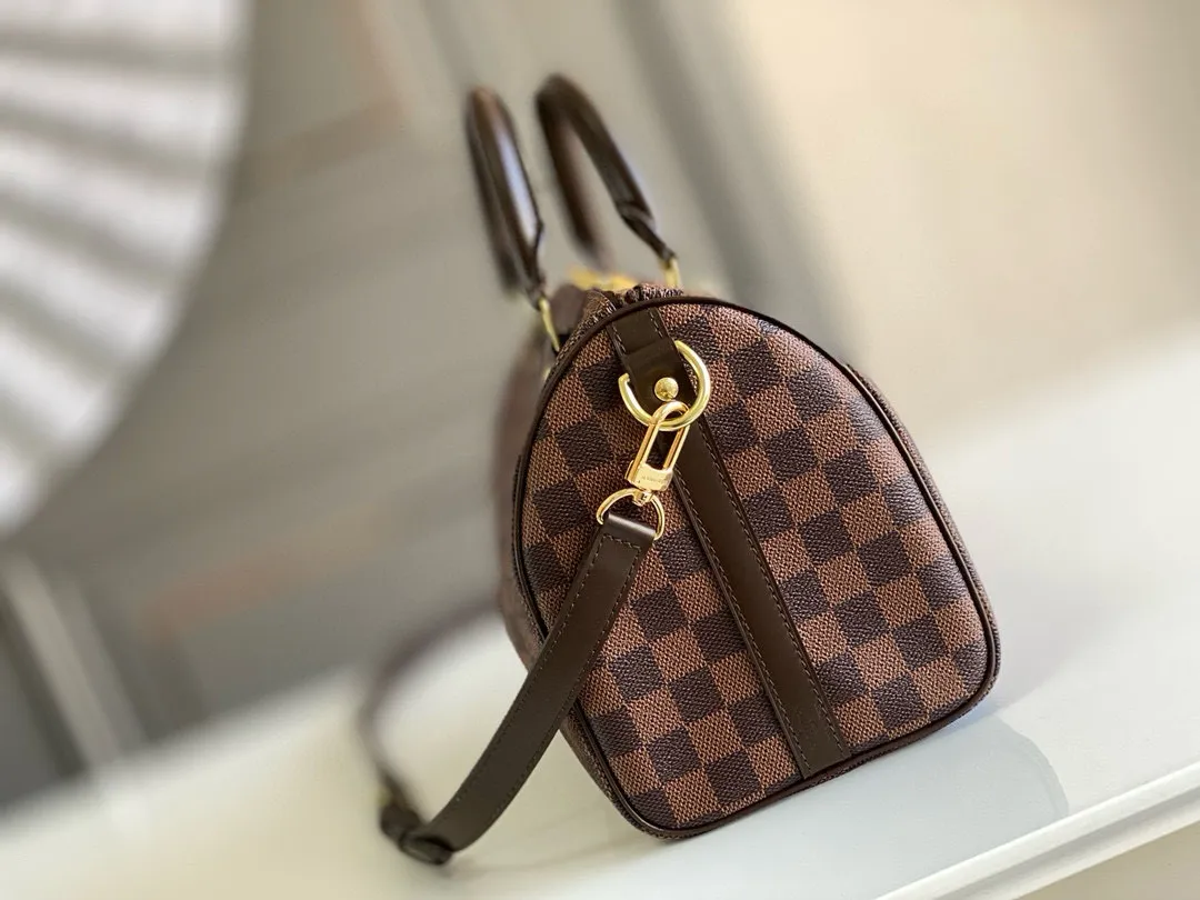 💰760 Top original order N41368 SPEEDY 25 handbag (with shoulder strap) The Speedy 25 handbag made of iconic Damier Ebène canvas shows the classic Louis Vuitton charm. Whether this bag is carried by hand, carried on the shoulder or cross-body, the user exudes endless elegance. Detailed Features 25 x 19 x 15 cm (Length x Height x Width) Smooth leather trim Shiny gold-tone brass hardware Double zip closure with padlock Internal pocket D-ring for keys and accessories Soft fabric lining Shoulder strap: Removable, adjustable Strap half-length: 46.5 cm Strap half-length adjustable to: 55.0 cm Handle: Double handle