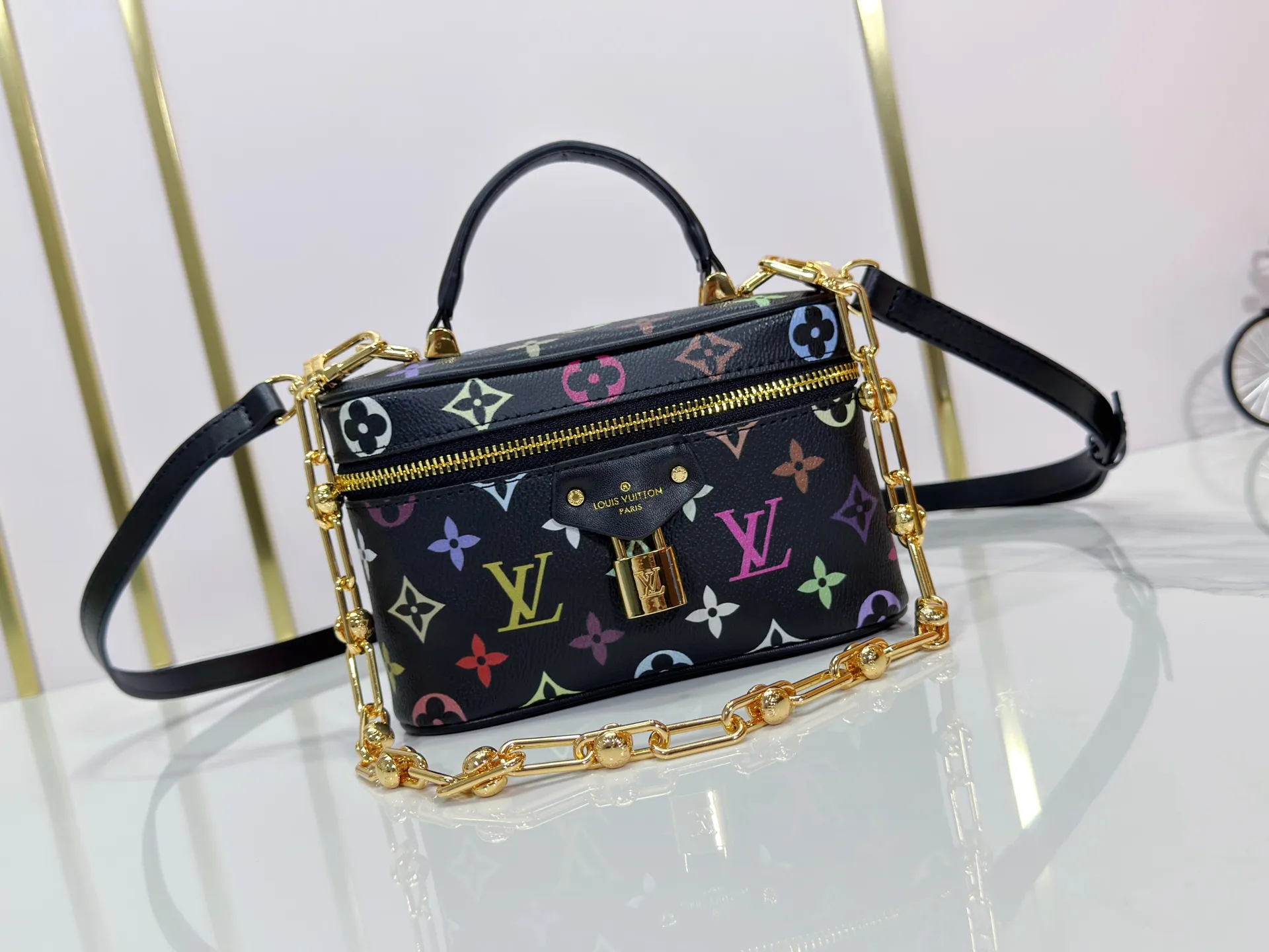 P280 Upgraded original M13662 This Vanity Pouch handbag is from the Louis Vuitton x Takashi Murakami reissue series, reinterpreting the brand's classic Monogram pattern with the artist's distinctive tones. Coated canvas is trimmed with calfskin, while a zipper closure, detachable chain and LV-engraved padlock add a metallic sheen. Dimensions: 11.5 x 6.5 x 19 cm (height x width x length)