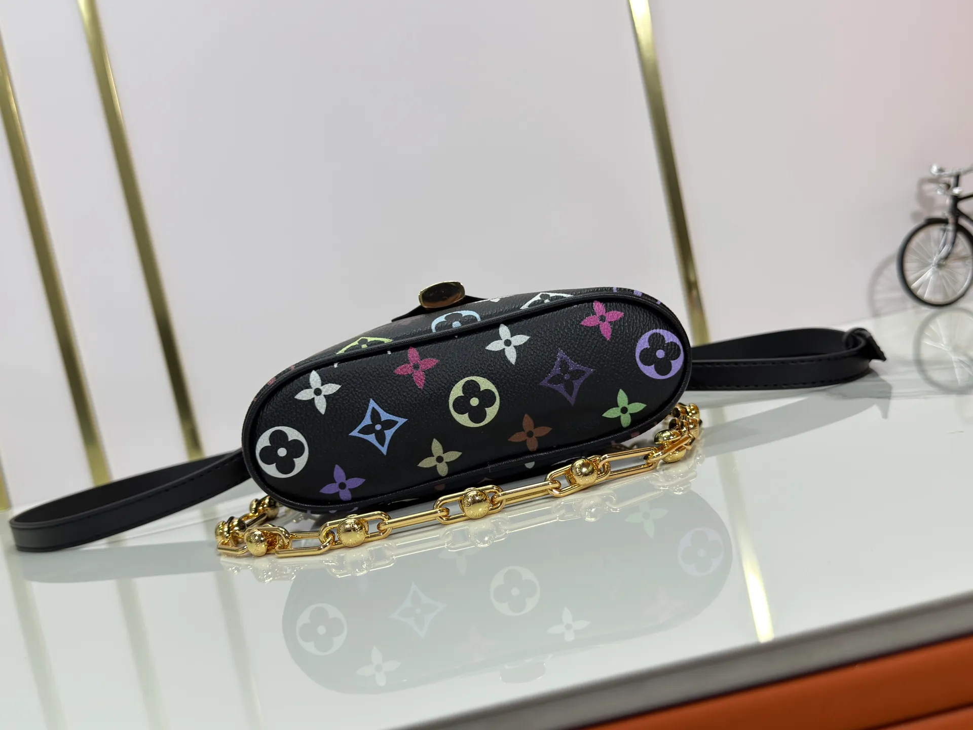 P280 Upgraded original M13662 This Vanity Pouch handbag is from the Louis Vuitton x Takashi Murakami reissue series, reinterpreting the brand's classic Monogram pattern with the artist's distinctive tones. Coated canvas is trimmed with calfskin, while a zipper closure, detachable chain and LV-engraved padlock add a metallic sheen. Dimensions: 11.5 x 6.5 x 19 cm (height x width x length)