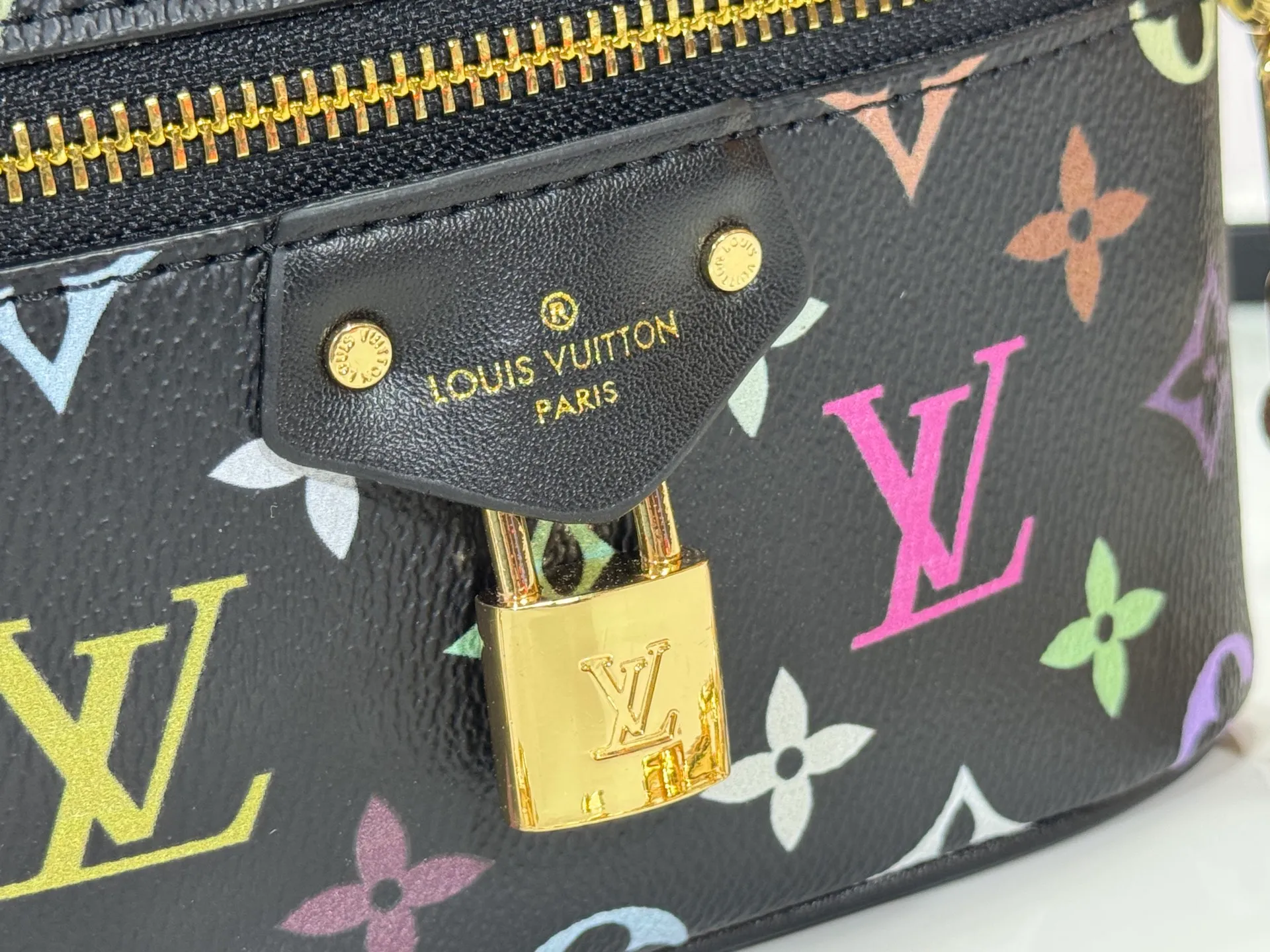 P280 Upgraded original M13662 This Vanity Pouch handbag is from the Louis Vuitton x Takashi Murakami reissue series, reinterpreting the brand's classic Monogram pattern with the artist's distinctive tones. Coated canvas is trimmed with calfskin, while a zipper closure, detachable chain and LV-engraved padlock add a metallic sheen. Dimensions: 11.5 x 6.5 x 19 cm (height x width x length)