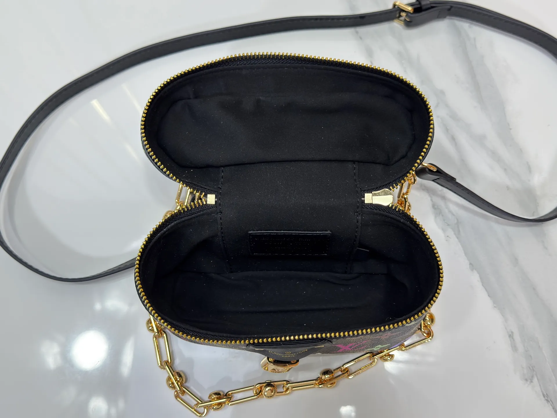 P280 Upgraded original M13662 This Vanity Pouch handbag is from the Louis Vuitton x Takashi Murakami reissue series, reinterpreting the brand's classic Monogram pattern with the artist's distinctive tones. Coated canvas is trimmed with calfskin, while a zipper closure, detachable chain and LV-engraved padlock add a metallic sheen. Dimensions: 11.5 x 6.5 x 19 cm (height x width x length)