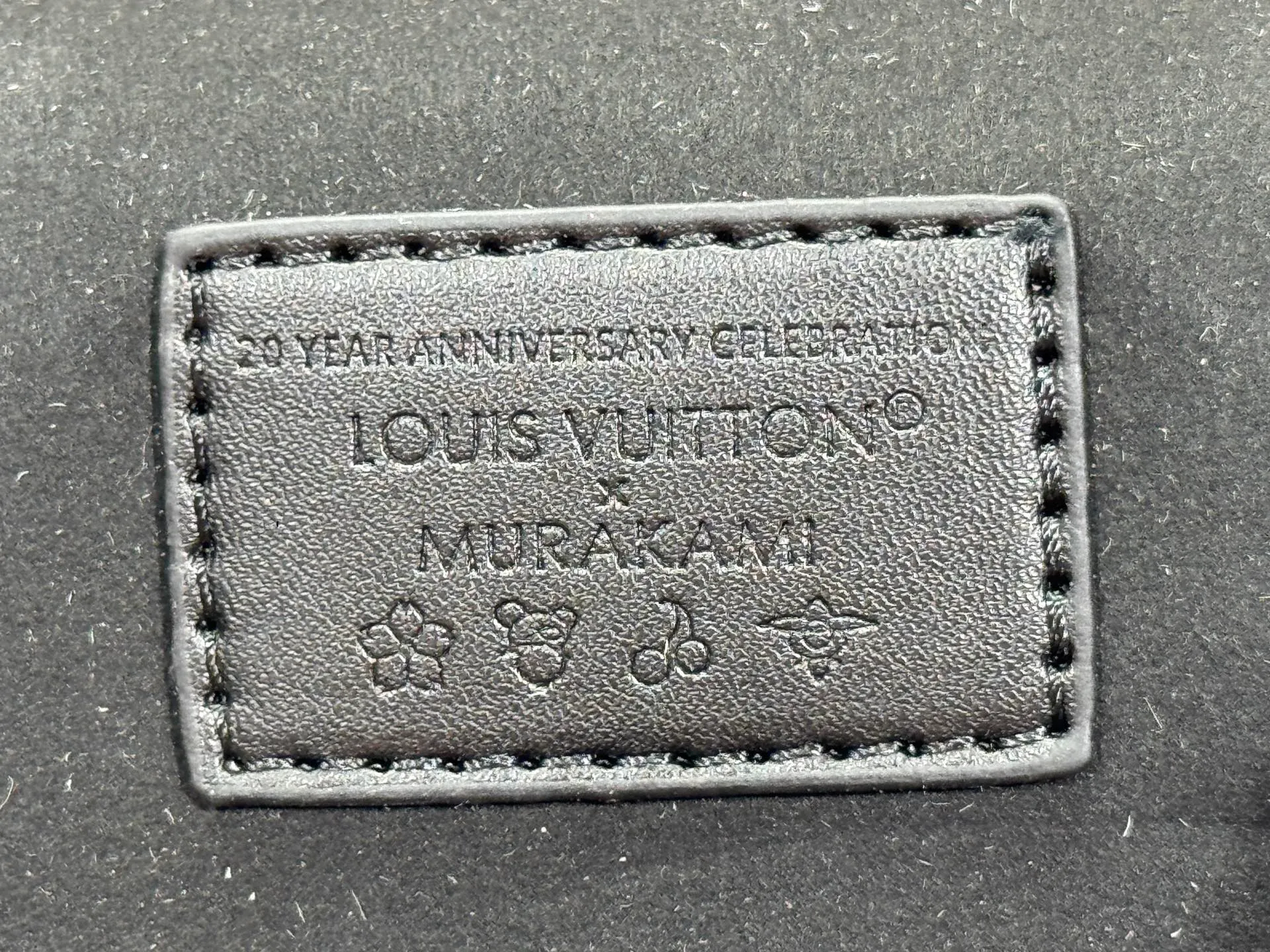 P280 Upgraded original M13662 This Vanity Pouch handbag is from the Louis Vuitton x Takashi Murakami reissue series, reinterpreting the brand's classic Monogram pattern with the artist's distinctive tones. Coated canvas is trimmed with calfskin, while a zipper closure, detachable chain and LV-engraved padlock add a metallic sheen. Dimensions: 11.5 x 6.5 x 19 cm (height x width x length)