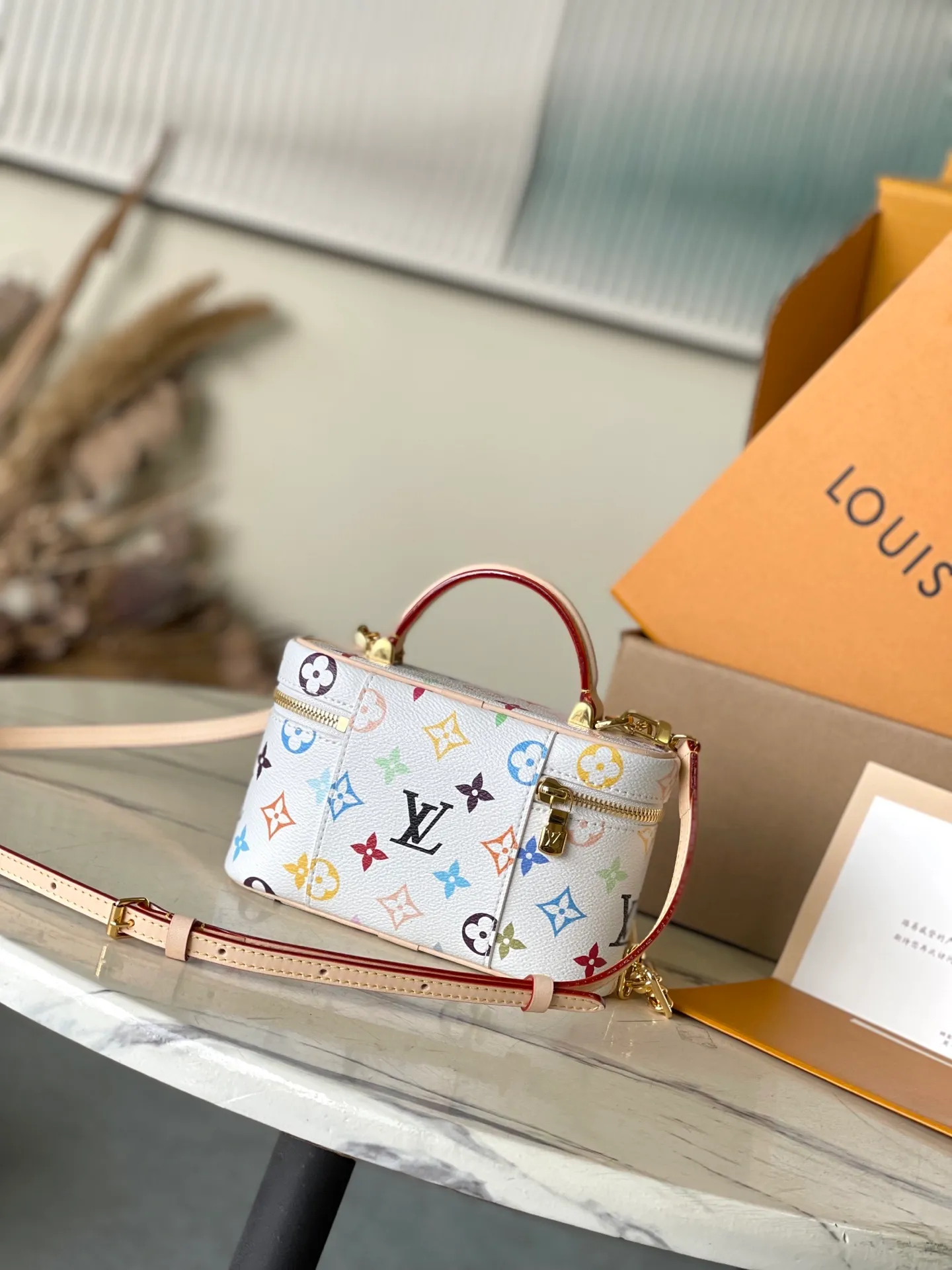 💰900 Top Original Order M13662 This Vanity Pouch handbag is from the Louis Vuitton x Murakami reissue series, reinterpreting the brand's classic Monogram pattern with the artist's bright tones. The coated canvas is trimmed with cow leather, and the zipper closure, detachable chain and LV-engraved padlock add a metallic sheen. Dimensions: 19 × 11.5 × 6.5 cm