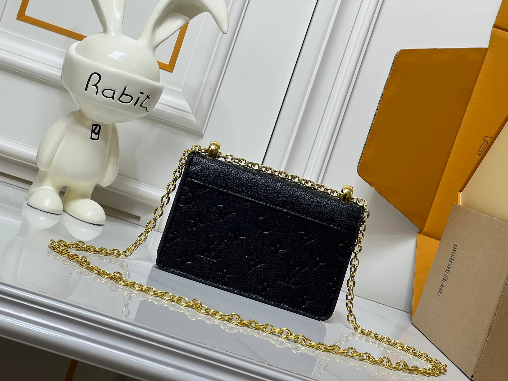Batch 220💰M13569 black M13570 gray M25814 burgundy (chain/embossed) [Portefeuille chaîne Rosy] This Rosy chain wallet is both fashionable and practical, adding a modern spirit to the Monogram Empreinte series. It has an elegant LV circle and a V-shaped flap, two hallmarks of the house. The magnetic closure reveals a surprise Monogram flower, as well as three card slots and a flat interior pocket. The sliding chain allows you to wear it crosswise or over the shoulder.  Dimensions: 19.5 x 13.5 x 6.5 cm