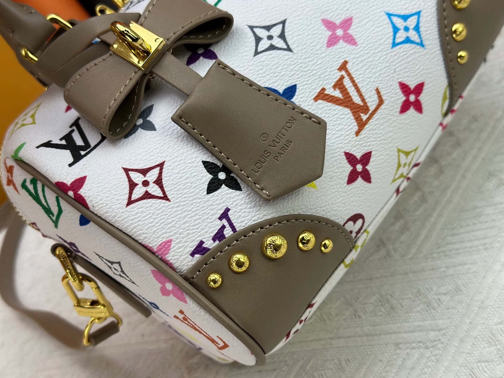 P260 upgraded original M58953 M46234 M46222 Speedy Bandoulière 20 handbag is made of soft coated canvas, and the full-length Monogram pattern is traced in colorful rainbow tones, highlighting the smart style of the Louis Vuitton x Murakami reissue series. The Toron handle and detachable shoulder strap are constructed of cow leather, the metal corners recall classic luggage elements, and the bow-shaped key bag and padlock add brand touches. Dimensions: 20.5 x 13.5 x 12.0 cm (length x height x width)