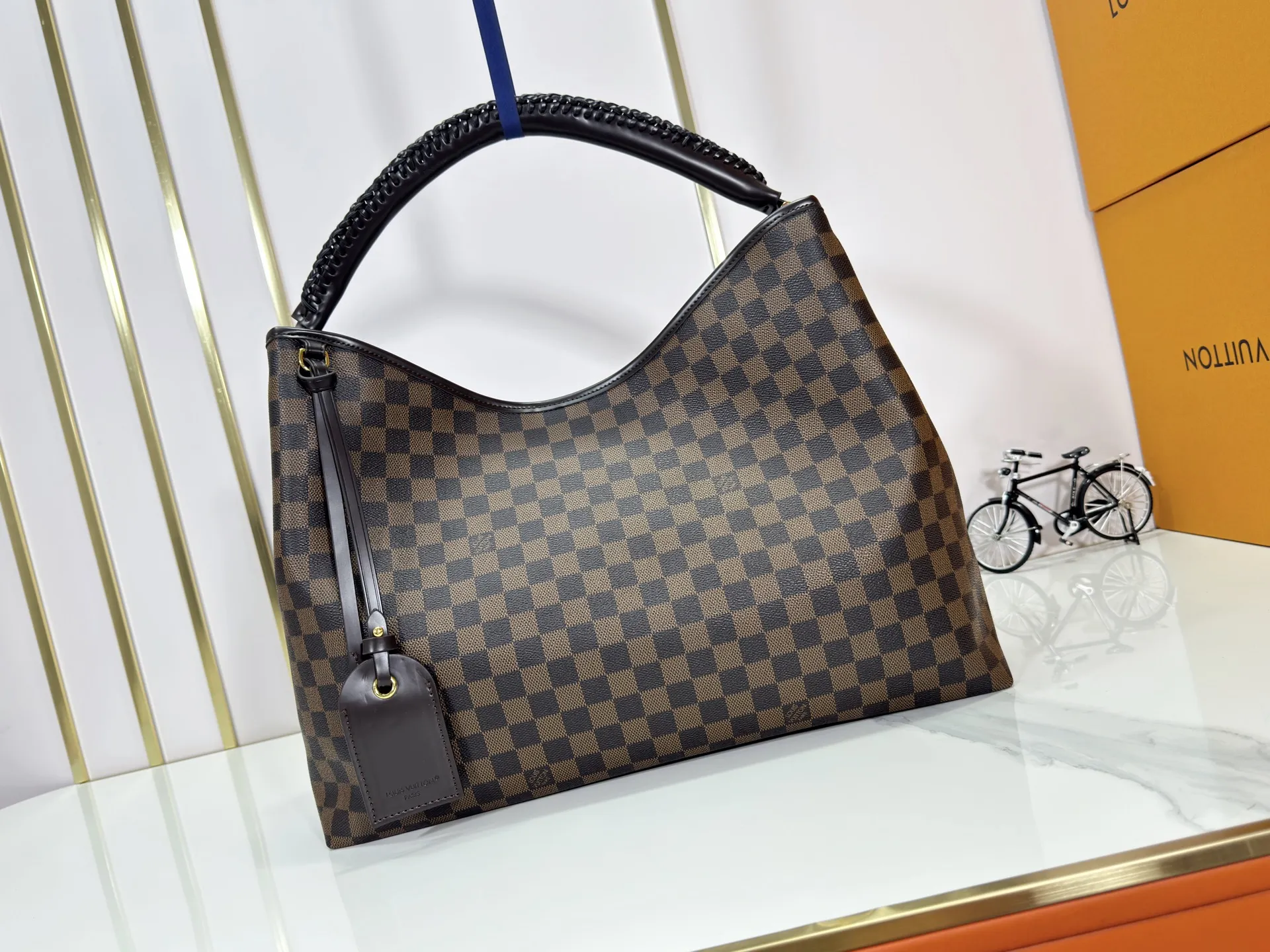 P280 upgrades the original M25877 Again handbag, a new interpretation of the iconic Artsy design first launched in 2010, now more flexible, more iconic and more refined. Rooted in LV’s DNA, this bag pays homage to Louis Vuitton’s craftsmanship with its classic Monogram canvas base, hand-woven handles and customizable name tag. It's spacious enough to hold a laptop and opens to reveal multiple pockets. Gold hooks can be used to hang playful accessories! ! Size:50x30x15.5CM