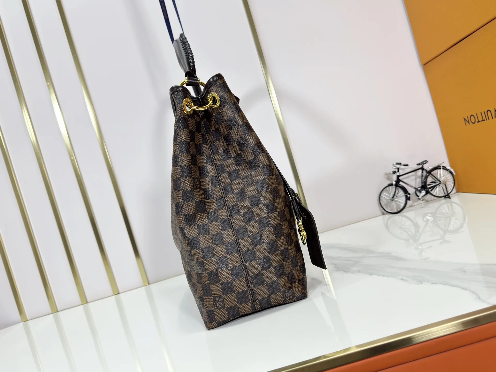 P280 upgrades the original M25877 Again handbag, a new interpretation of the iconic Artsy design first launched in 2010, now more flexible, more iconic and more refined. Rooted in LV’s DNA, this bag pays homage to Louis Vuitton’s craftsmanship with its classic Monogram canvas base, hand-woven handles and customizable name tag. It's spacious enough to hold a laptop and opens to reveal multiple pockets. Gold hooks can be used to hang playful accessories! ! Size:50x30x15.5CM