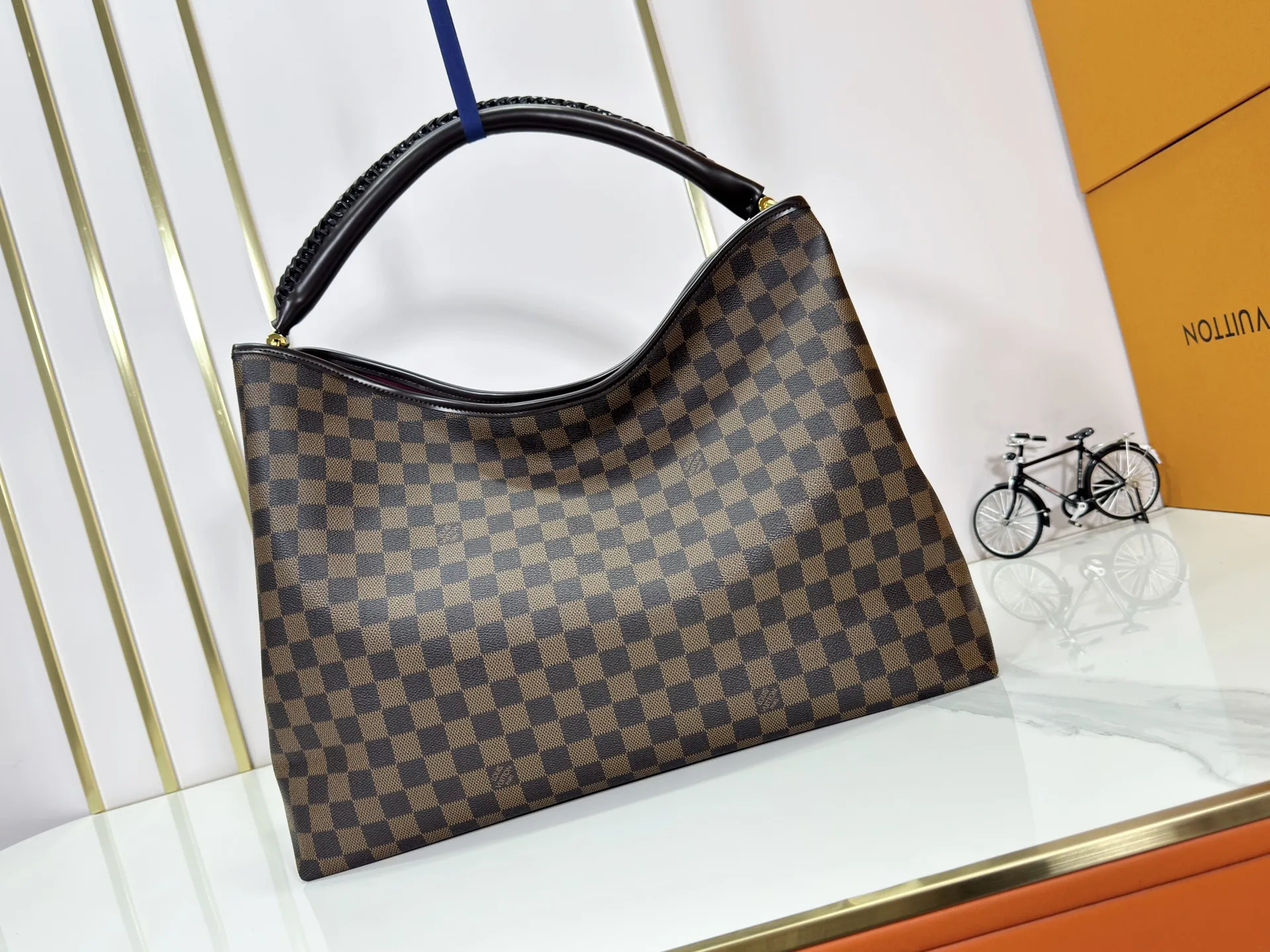 P280 upgrades the original M25877 Again handbag, a new interpretation of the iconic Artsy design first launched in 2010, now more flexible, more iconic and more refined. Rooted in LV’s DNA, this bag pays homage to Louis Vuitton’s craftsmanship with its classic Monogram canvas base, hand-woven handles and customizable name tag. It's spacious enough to hold a laptop and opens to reveal multiple pockets. Gold hooks can be used to hang playful accessories! ! Size:50x30x15.5CM