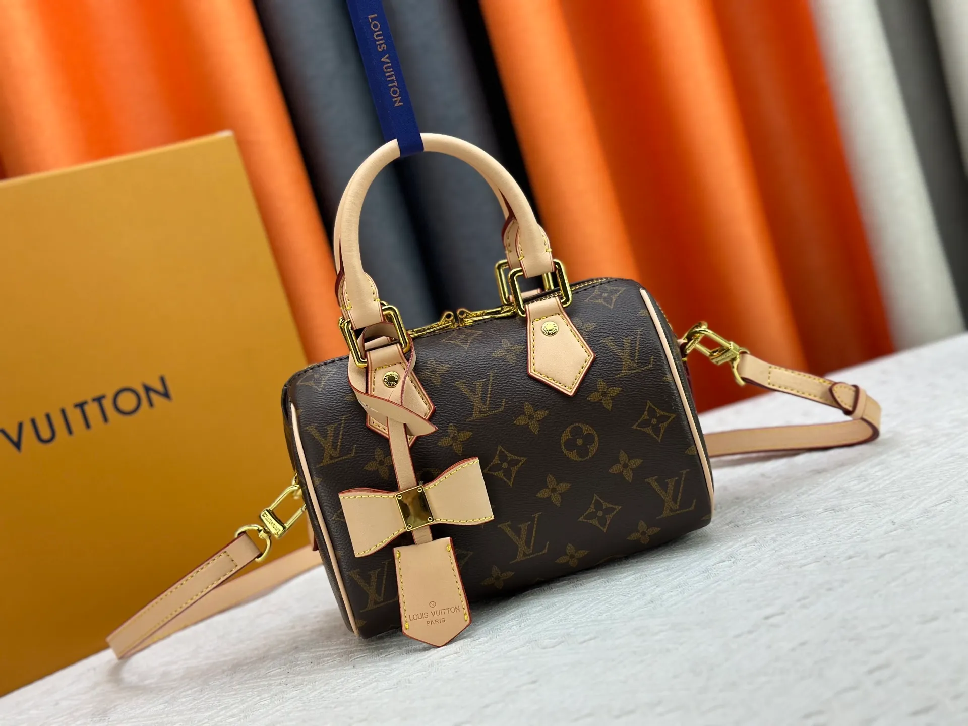 P260 Upgraded from the original version, this M46234 M46222 Speedy Bandoulière 20 handbag is made of soft coated canvas, with the full-length Monogram pattern traced in colorful rainbow tones, highlighting the smart style of the Louis Vuitton x Murakami reissue series. The Toron handle and detachable shoulder strap are constructed of cow leather, the metal corners recall classic luggage elements, and the bow-shaped key bag and padlock add brand touches. Dimensions: 20.5 x 13.5 x 12.0 cm (length x height x width)