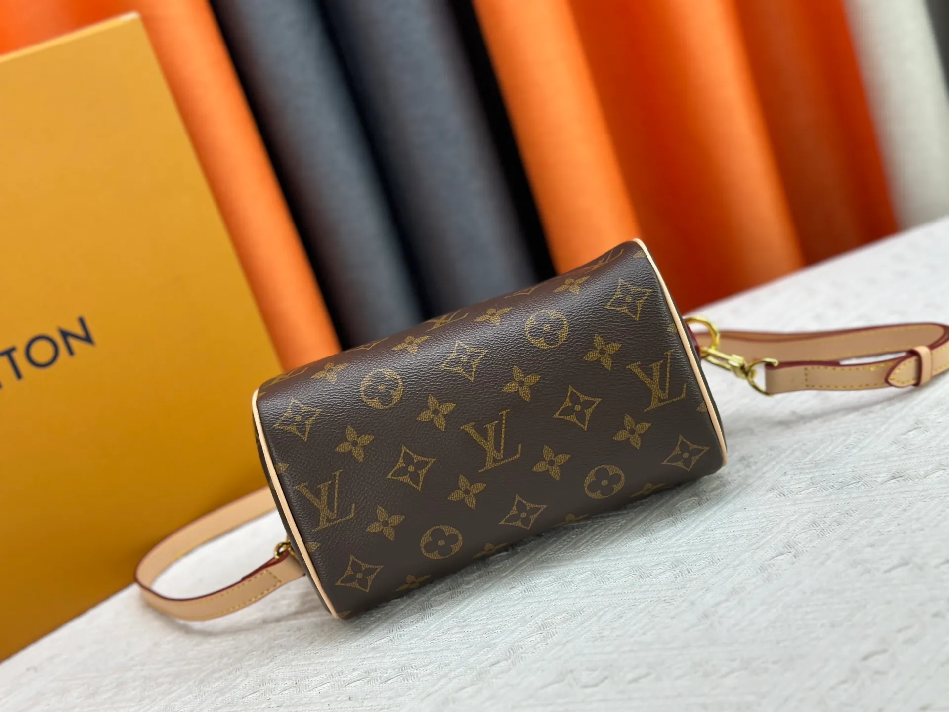 P260 Upgraded from the original version, this M46234 M46222 Speedy Bandoulière 20 handbag is made of soft coated canvas, with the full-length Monogram pattern traced in colorful rainbow tones, highlighting the smart style of the Louis Vuitton x Murakami reissue series. The Toron handle and detachable shoulder strap are constructed of cow leather, the metal corners recall classic luggage elements, and the bow-shaped key bag and padlock add brand touches. Dimensions: 20.5 x 13.5 x 12.0 cm (length x height x width)