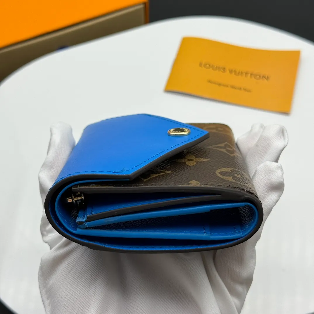 💰130 💎Upgraded original version🇫🇷 ZOÉ Wallet The Zoé wallet combines Damier Azur canvas and pastel leather to outline an envelope-like structure. The flip cover is decorated with gold Louis Vuitton snaps to welcome the coolness of summer. The compact design hides ample space, making it easy to store coins, banknotes and bank cards. It can also be placed in a pocket, handbag or clutch. Model: M60168 Dimensions: 9.5 x 7.5 x 3.0 cm (length x height x width).