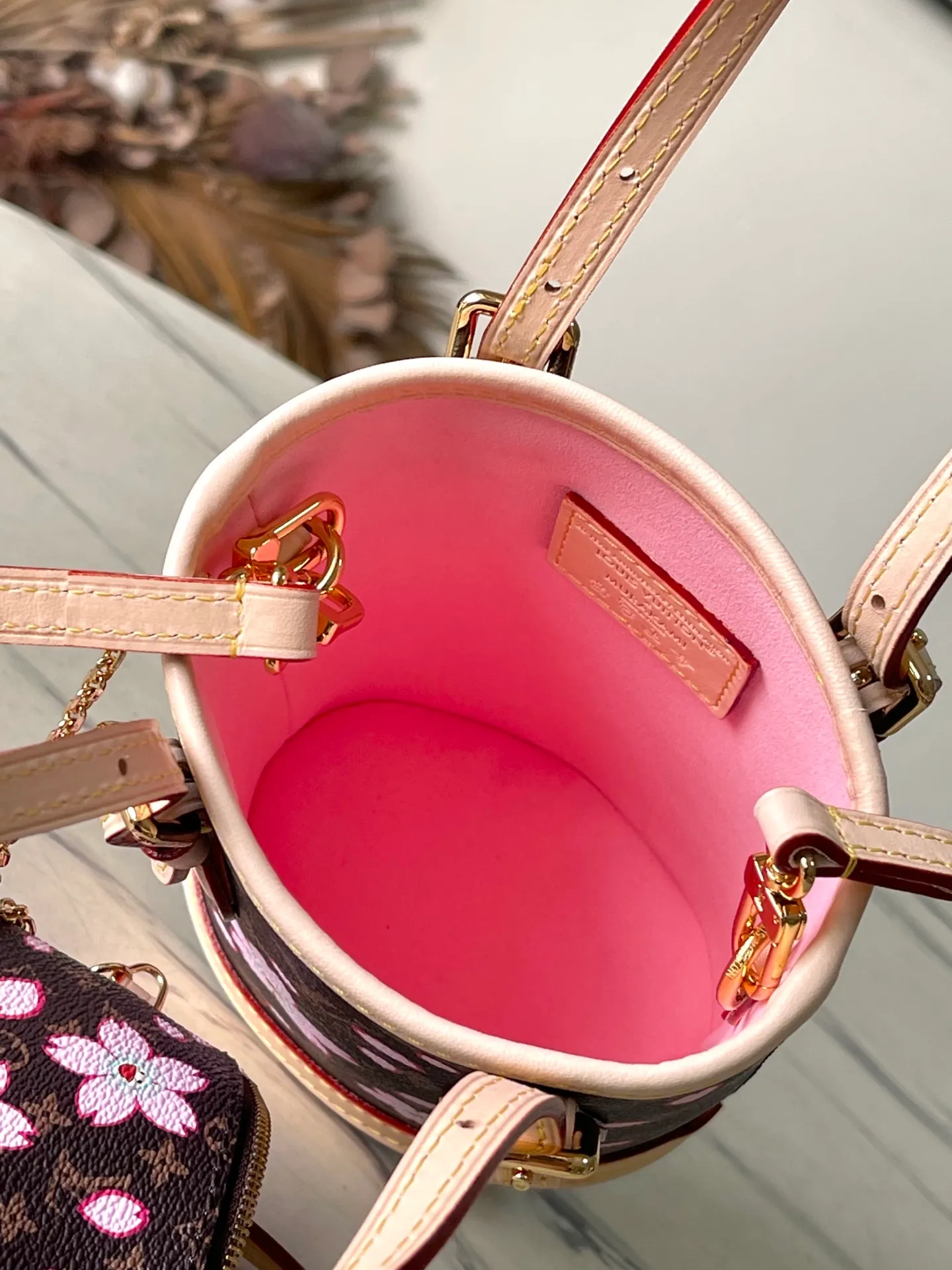 💰960 Top Original Order M13417 This Nano Bucket handbag is constructed of classic Monogram coated canvas with a sophisticated design, and is completed with cow leather trim and dazzling metal parts. The Cherry Blossom pattern on the body of the bag conveys the atmosphere of prosperous recovery and highlights the distinctive style of Japanese artist Takashi Murakami. The detachable shoulder strap allows for a variety of carrying options, and the leather keychain adds a functional detail. Dimensions: 13 × 17 × 9 cm
