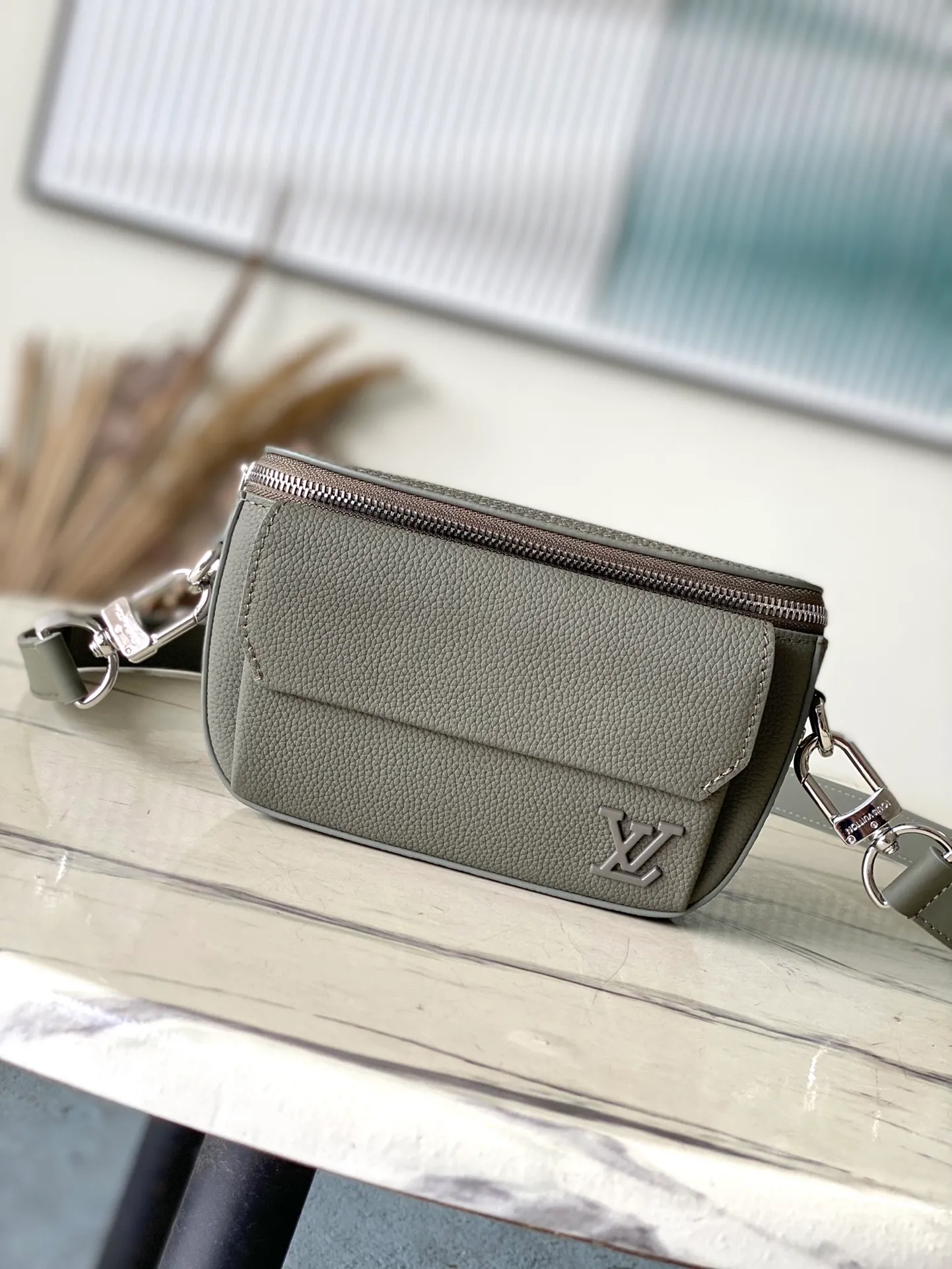 💰940 (top layer leather) top original order M83560 dark green This Pilot mini handbag is made of grained cow leather with a round shape, providing a trendy choice for daily travel. A zippered main compartment ensures secure storage, and a front pocket provides easy access to small items like your phone or keys. Detachable shoulder strap allows for comfortable shoulder or cross-body wear. Dimensions: 20 × 12 × 5,5 cm