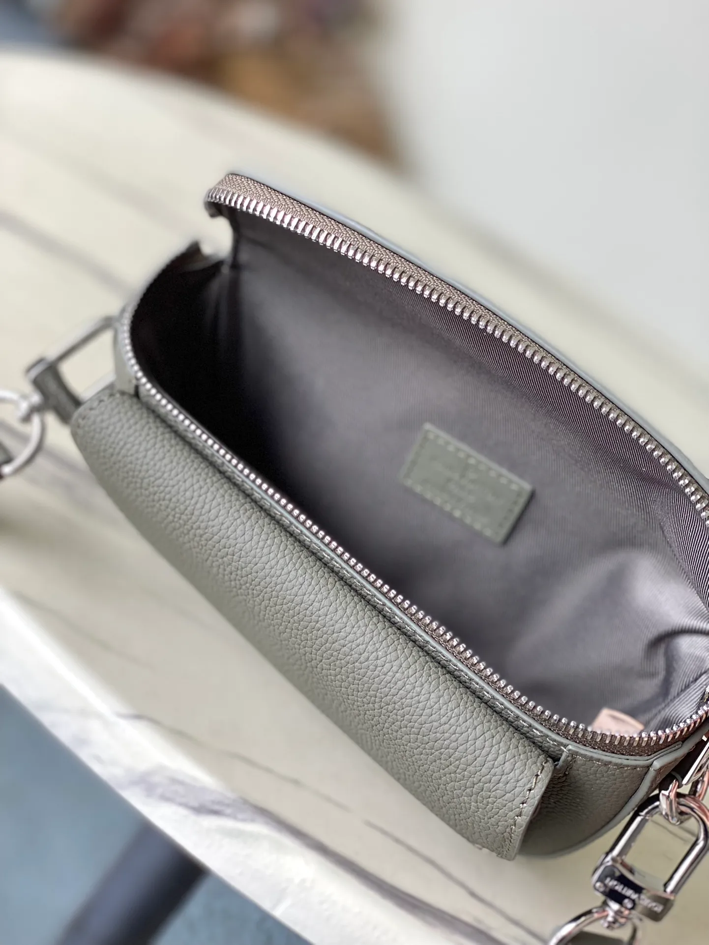 💰940 (top layer leather) top original order M83560 dark green This Pilot mini handbag is made of grained cow leather with a round shape, providing a trendy choice for daily travel. A zippered main compartment ensures secure storage, and a front pocket provides easy access to small items like your phone or keys. Detachable shoulder strap allows for comfortable shoulder or cross-body wear. Dimensions: 20 × 12 × 5,5 cm