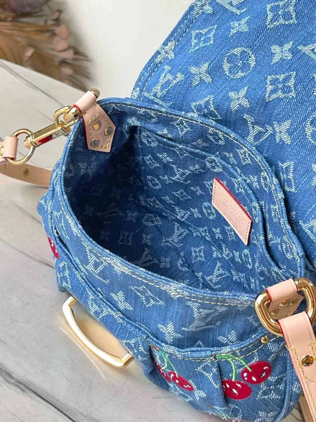 💰1180 Top original order M13680 This Sunset handbag is made of Monogram denim, with retro brushstrokes to create a rounded shape, and eye-catching buckles to brighten the design. The bright cherry embroidery highlights the smart style of the Louis Vuitton×Murakami replica series, and the studded leather shoulder strap completes the whole. Dimensions: 27 × 18 × 3 cm