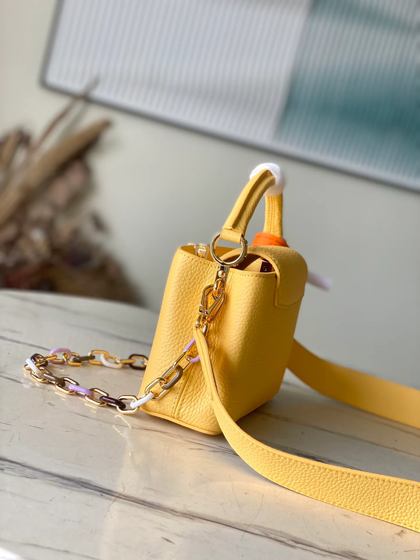 💰2460 (Special Original Leather) M21798 Lemon Yellow Mini This Capucines mini handbag has metal and resin links interlocking with each other, adding a fun detachable chain to the classic design. Taurillon leather has a shiny look, and the logo can be highlighted by placing the flap on the inside. Dimensions: 21 x 14 x 8 cm