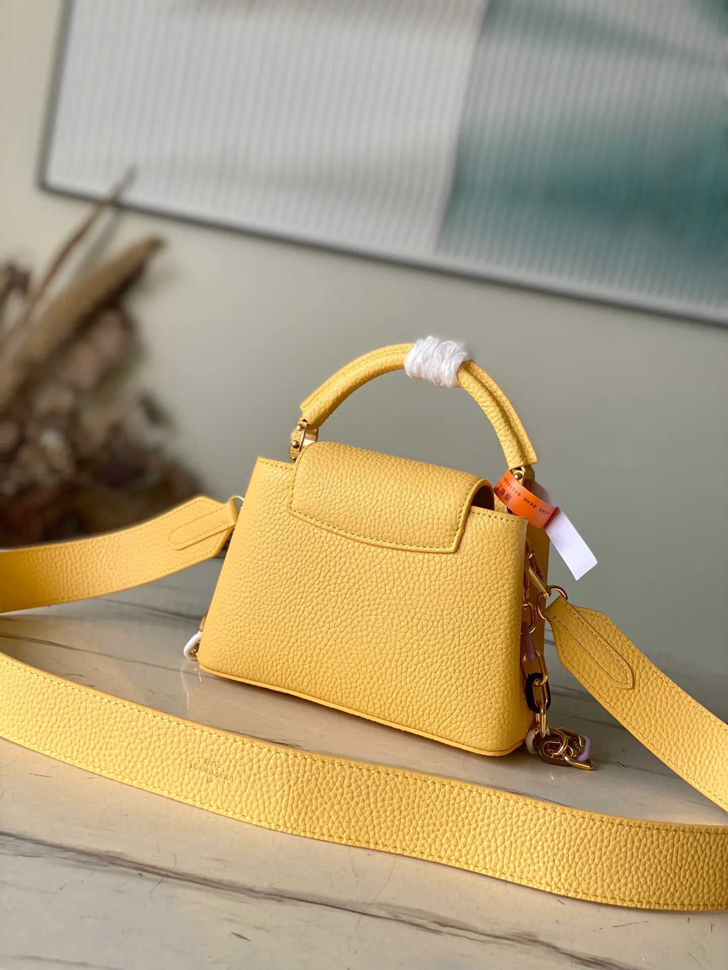 💰2460 (Special Original Leather) M21798 Lemon Yellow Mini This Capucines mini handbag has metal and resin links interlocking with each other, adding a fun detachable chain to the classic design. Taurillon leather has a shiny look, and the logo can be highlighted by placing the flap on the inside. Dimensions: 21 x 14 x 8 cm
