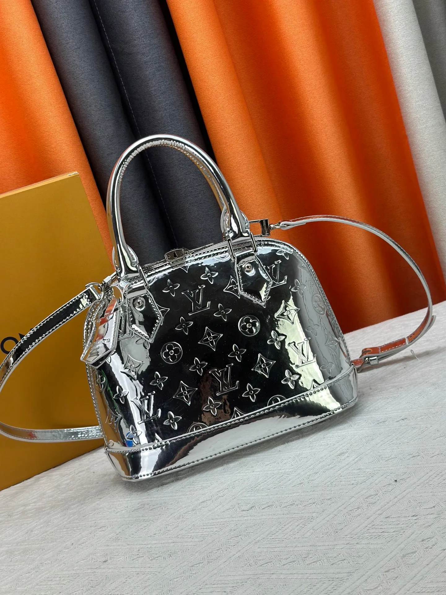 P300 M11835 M53151 M53152 The Alma medium handbag of the LVSki series draws inspiration from the Louis Vuitton archive hard box, rendering a new Monogram Miroir effect on the Monogram embossed coated canvas, highlighting the concept of retro futurism. Spacious interior patch pockets ensure organized storage. Size: 23.5x17.5x11.5cm